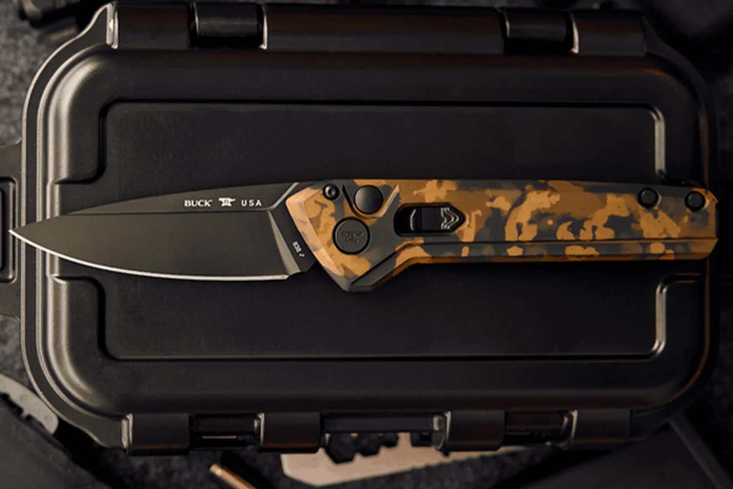 Black folding knife with a brown and black camouflage handle resting on a black hard case.