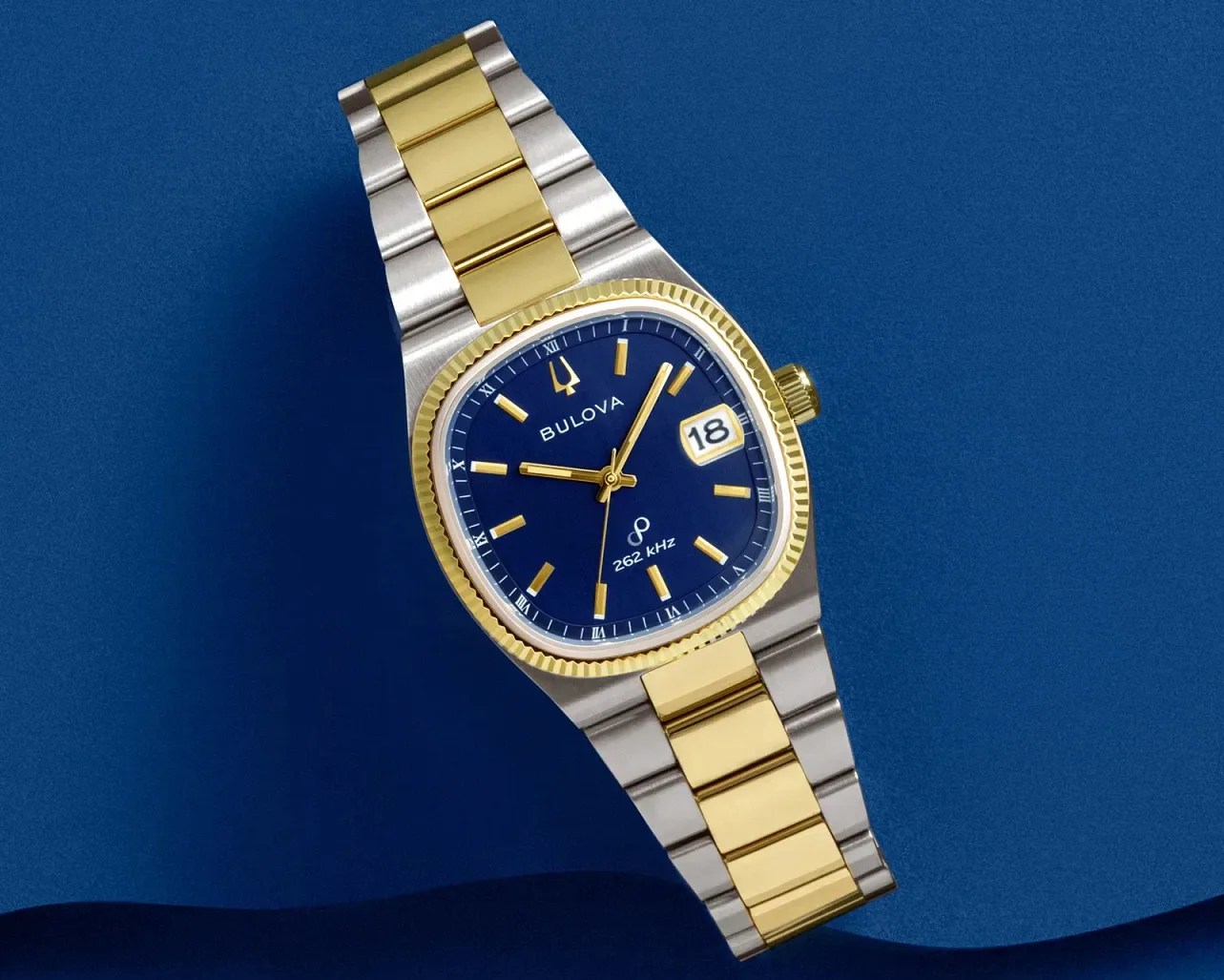 Two-tone stainless steel and gold wristwatch with a blue dial, gold markers, and date display at 3 o'clock.