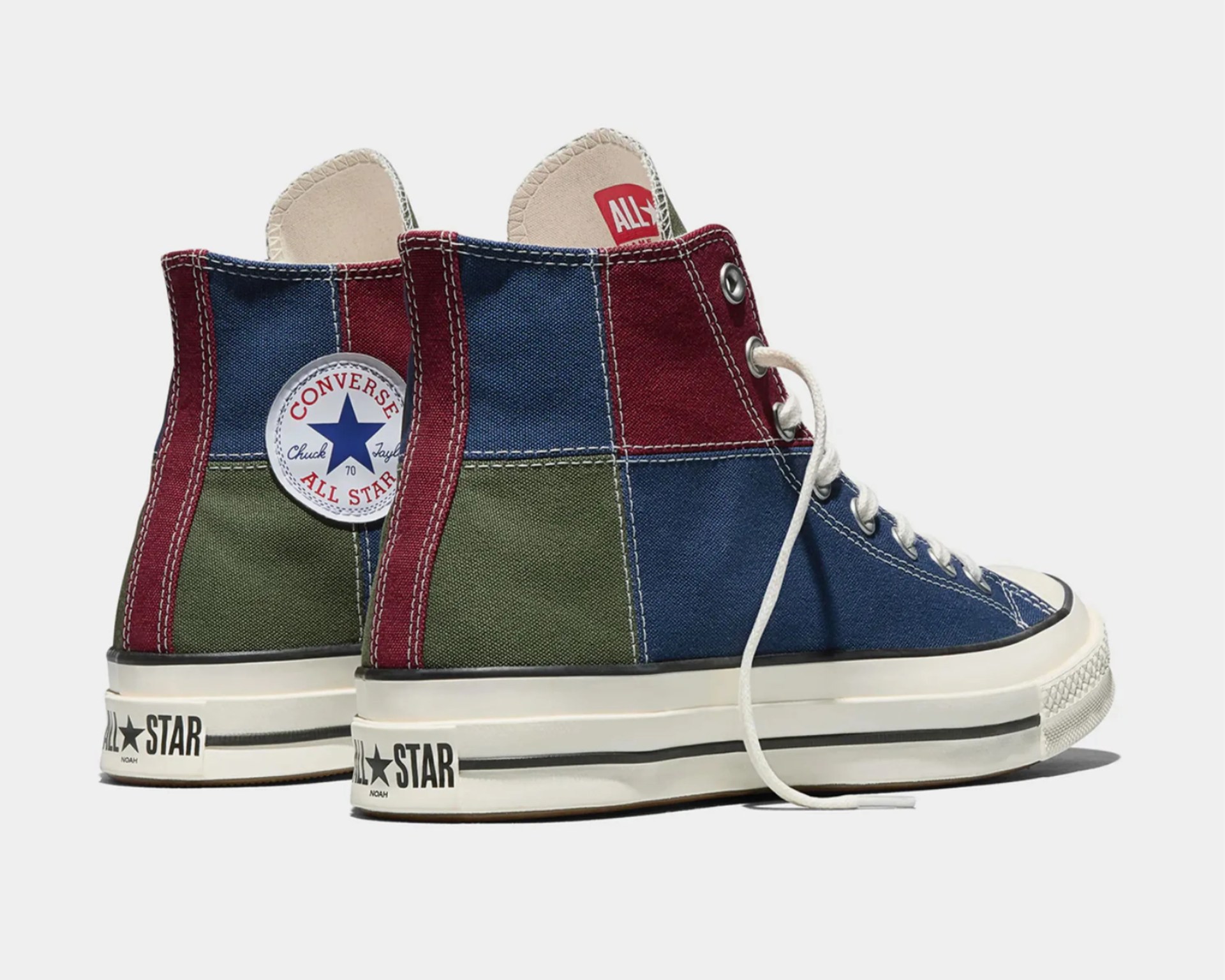 High-top Converse Chuck Taylor All Star sneakers in patchwork canvas with blue, green, and burgundy panels and white laces.