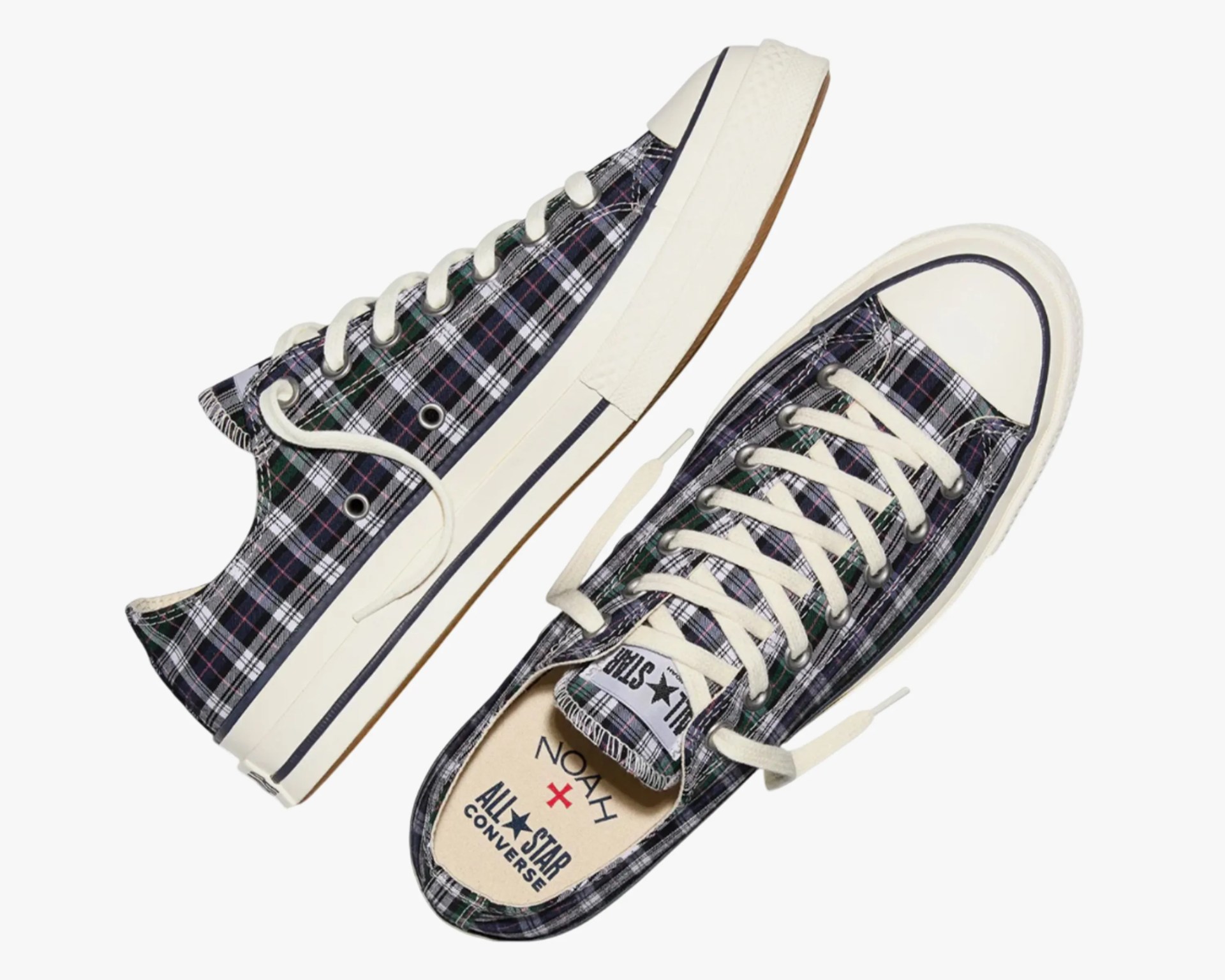 Pair of low-top Converse All Star sneakers with black, white, and green plaid pattern and white laces.