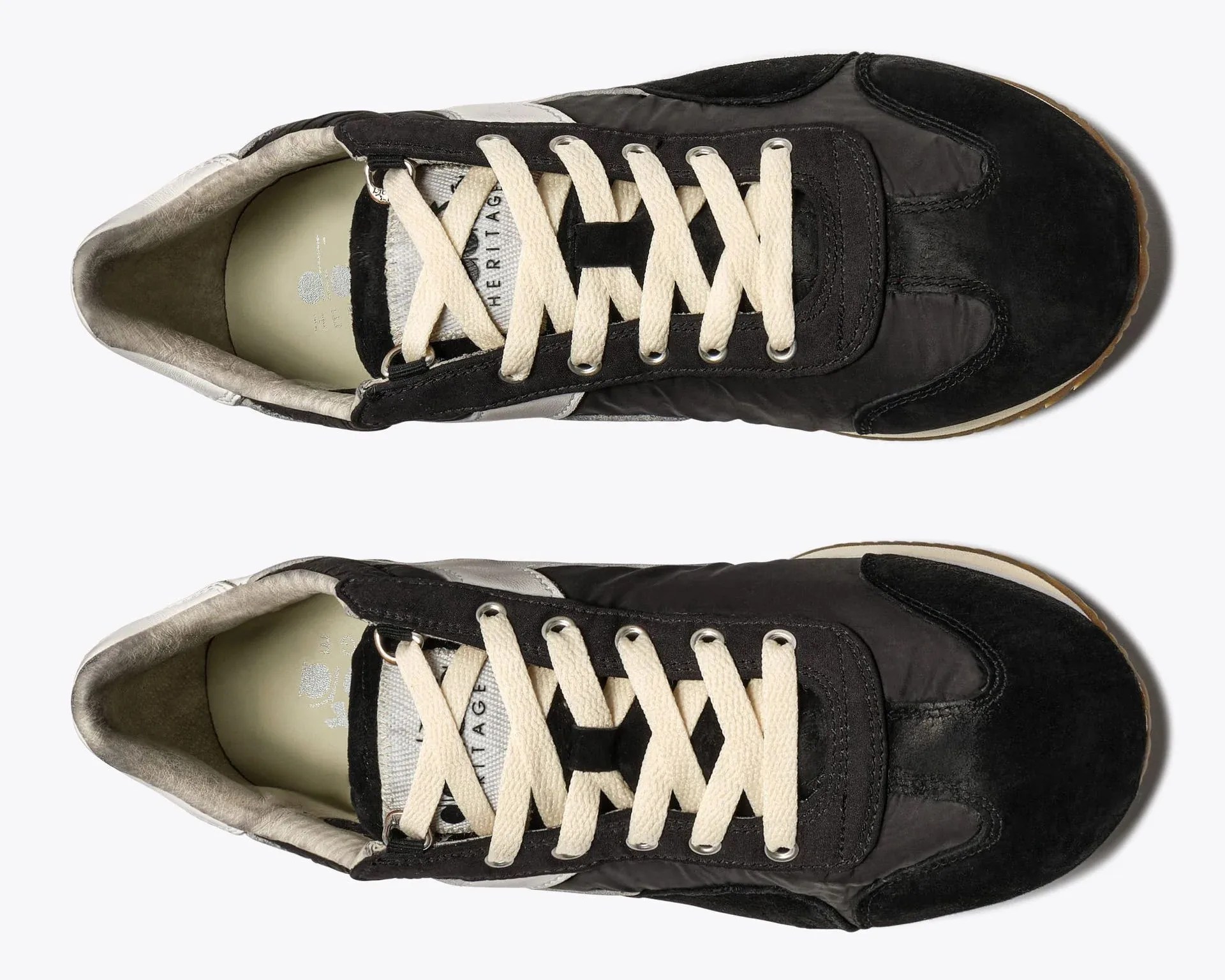Pair of black and gray sneakers with cream laces viewed from above on a white background.