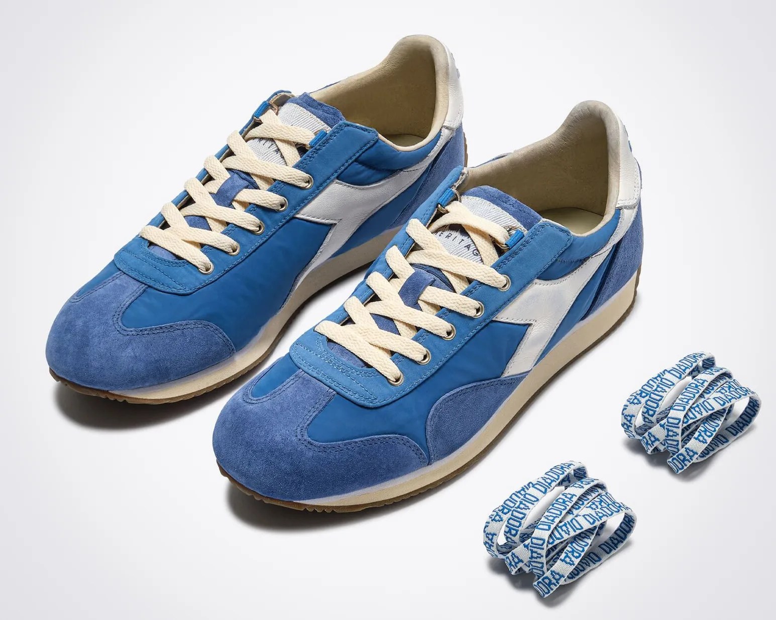 Pair of blue and white suede and nylon sneakers with cream laces and two sets of blue and white branded spare laces.