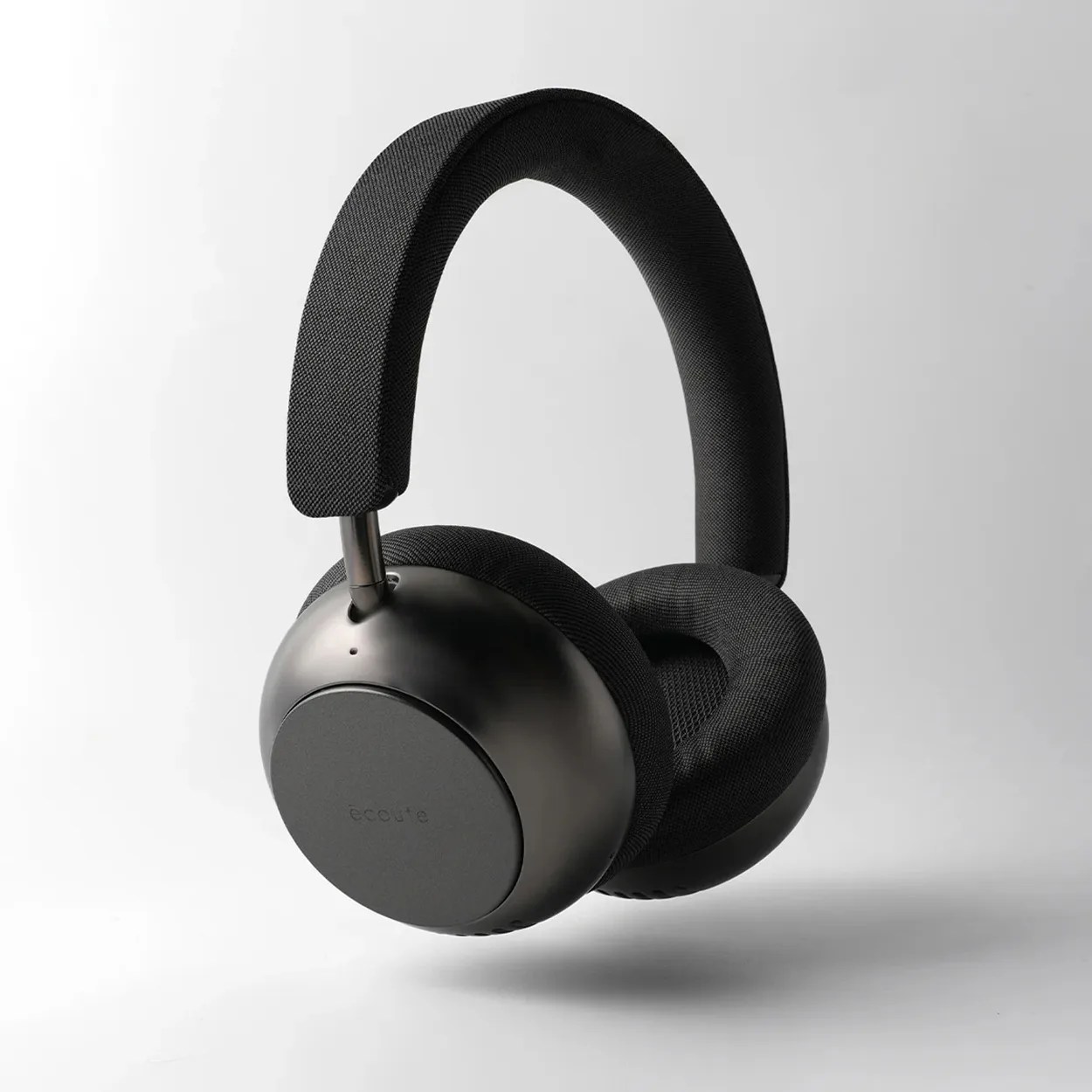 Black over-ear headphones with padded fabric ear cups and headband on a white background.