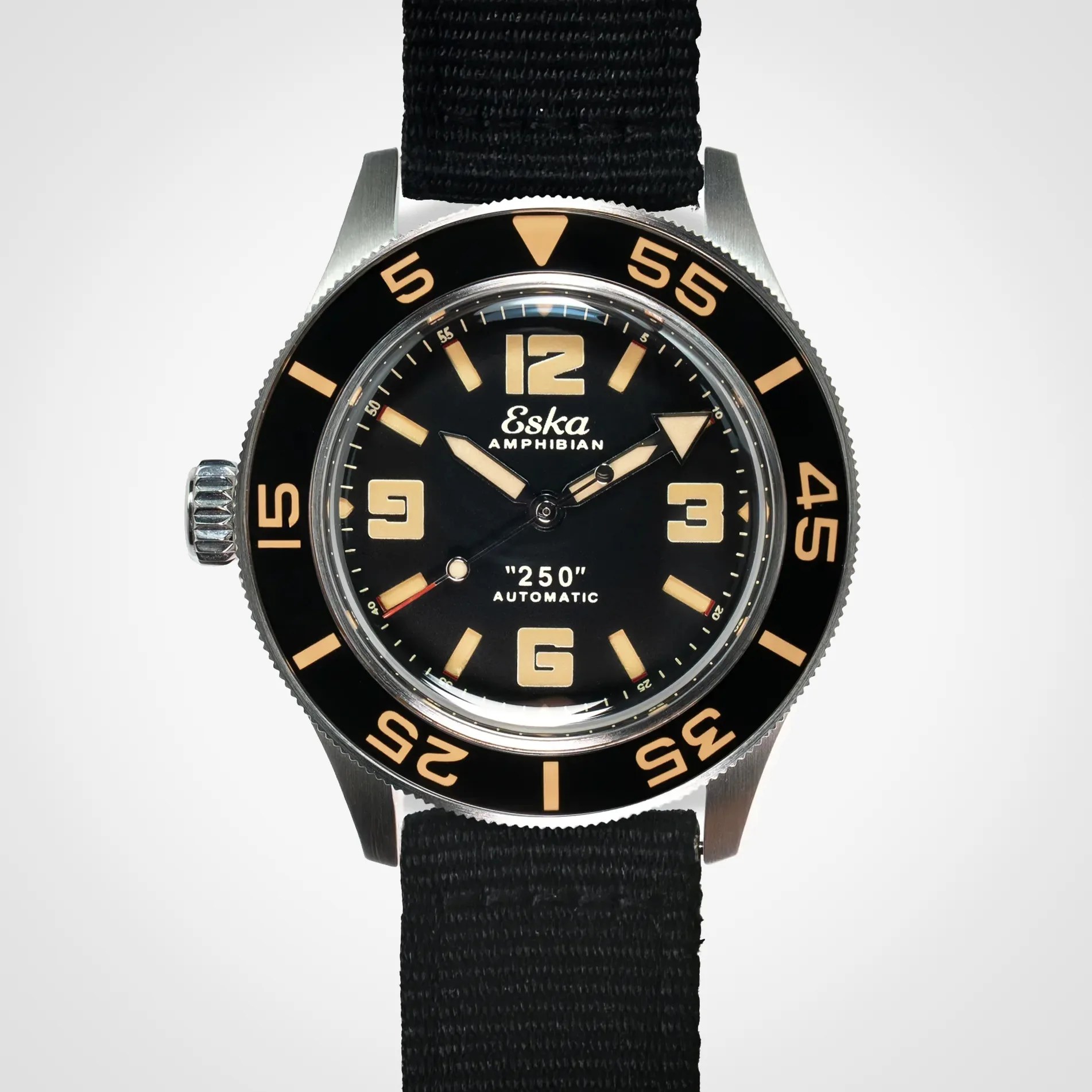Black Eska Amphibian automatic dive watch with beige numerals and markers on a black fabric strap.