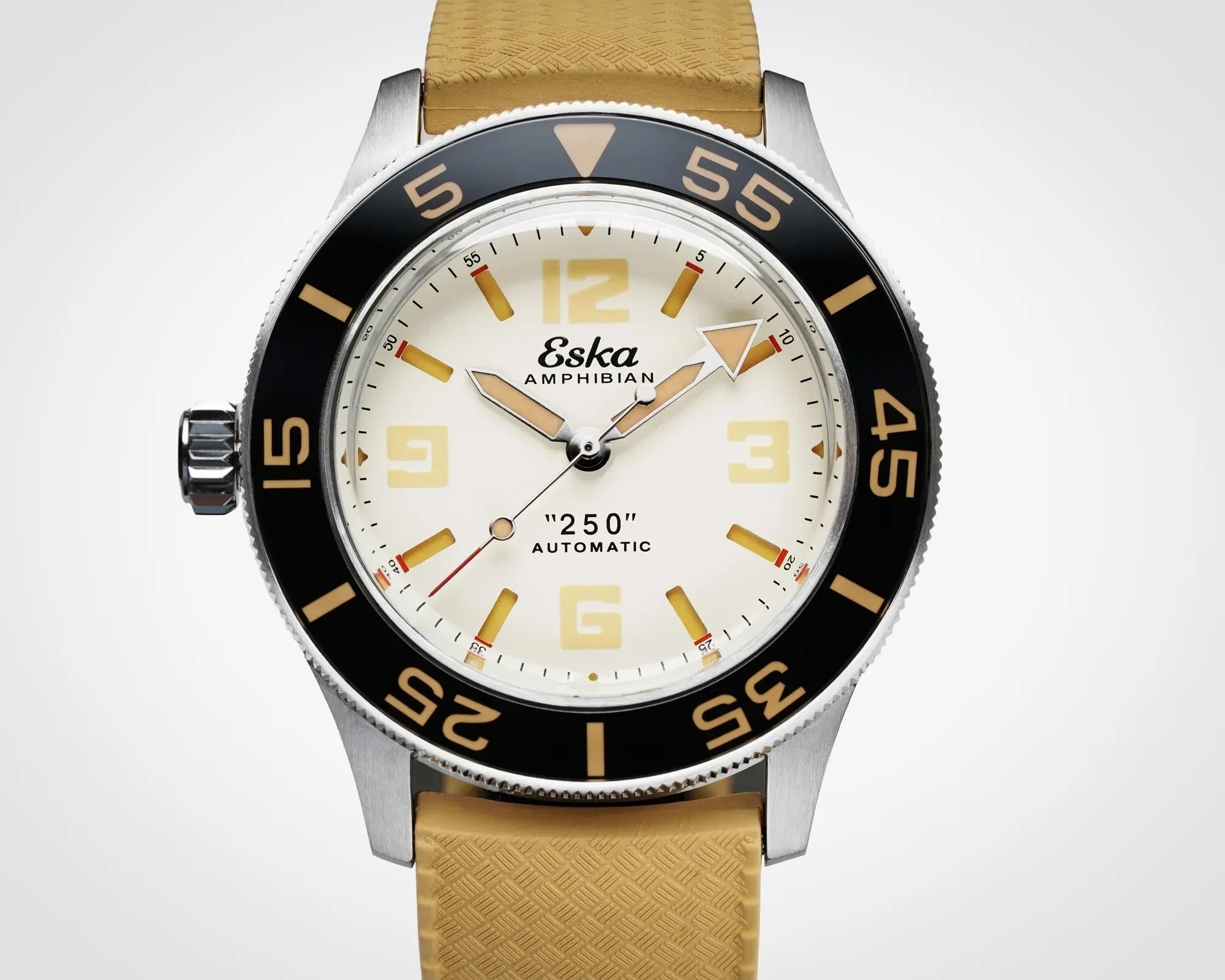 Silver Eska Amphibian automatic watch with black bezel, cream dial, tan markers, and tan textured strap.