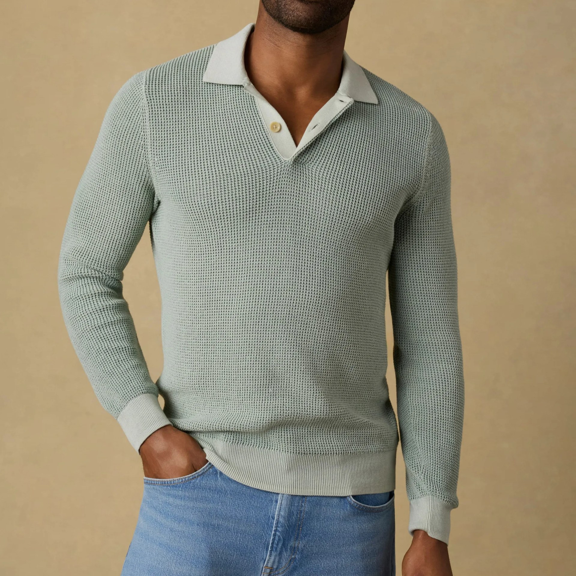 Light green waffle-knit long-sleeve polo sweater worn with light blue jeans.