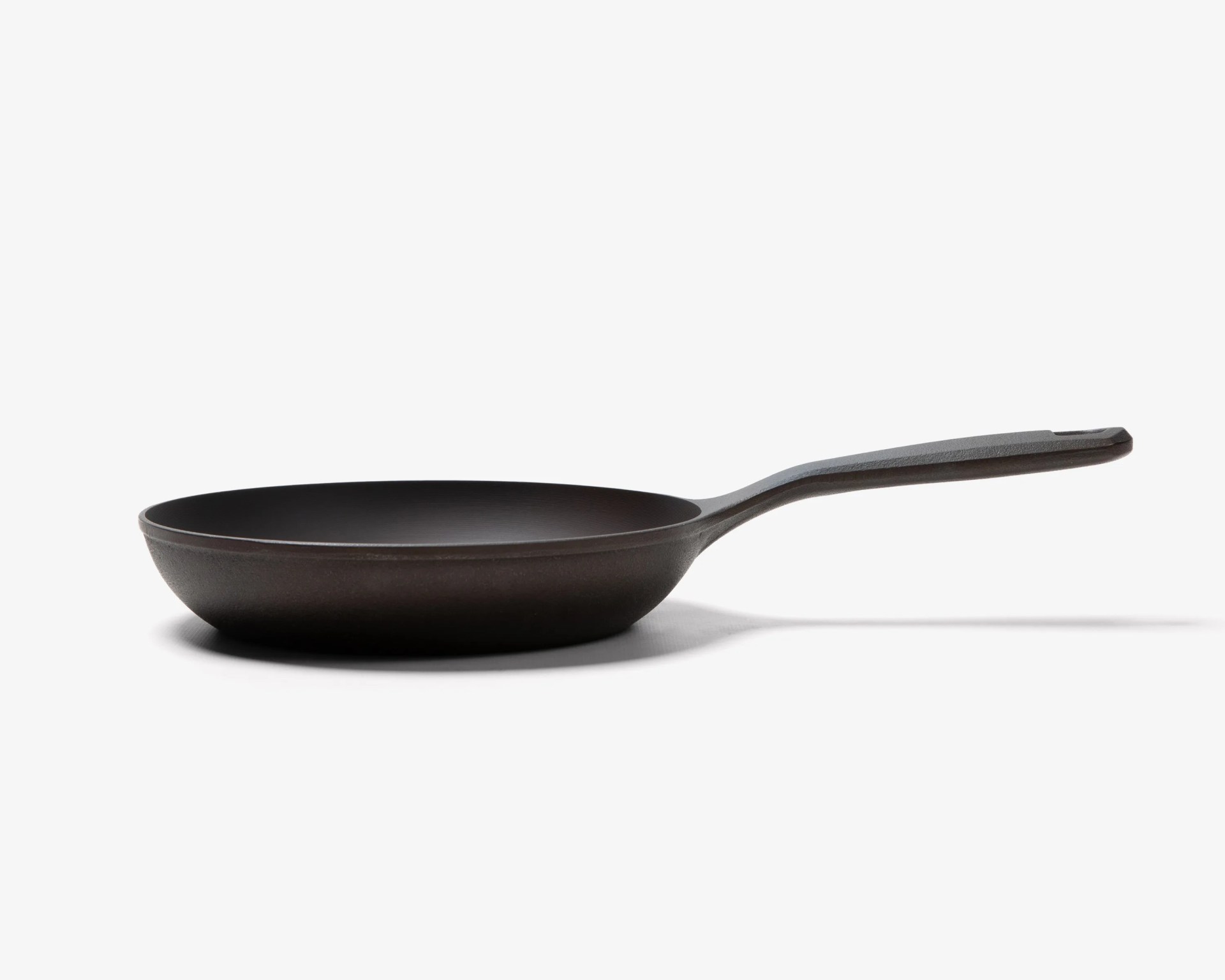 Black cast iron frying pan with a long handle on a white background.