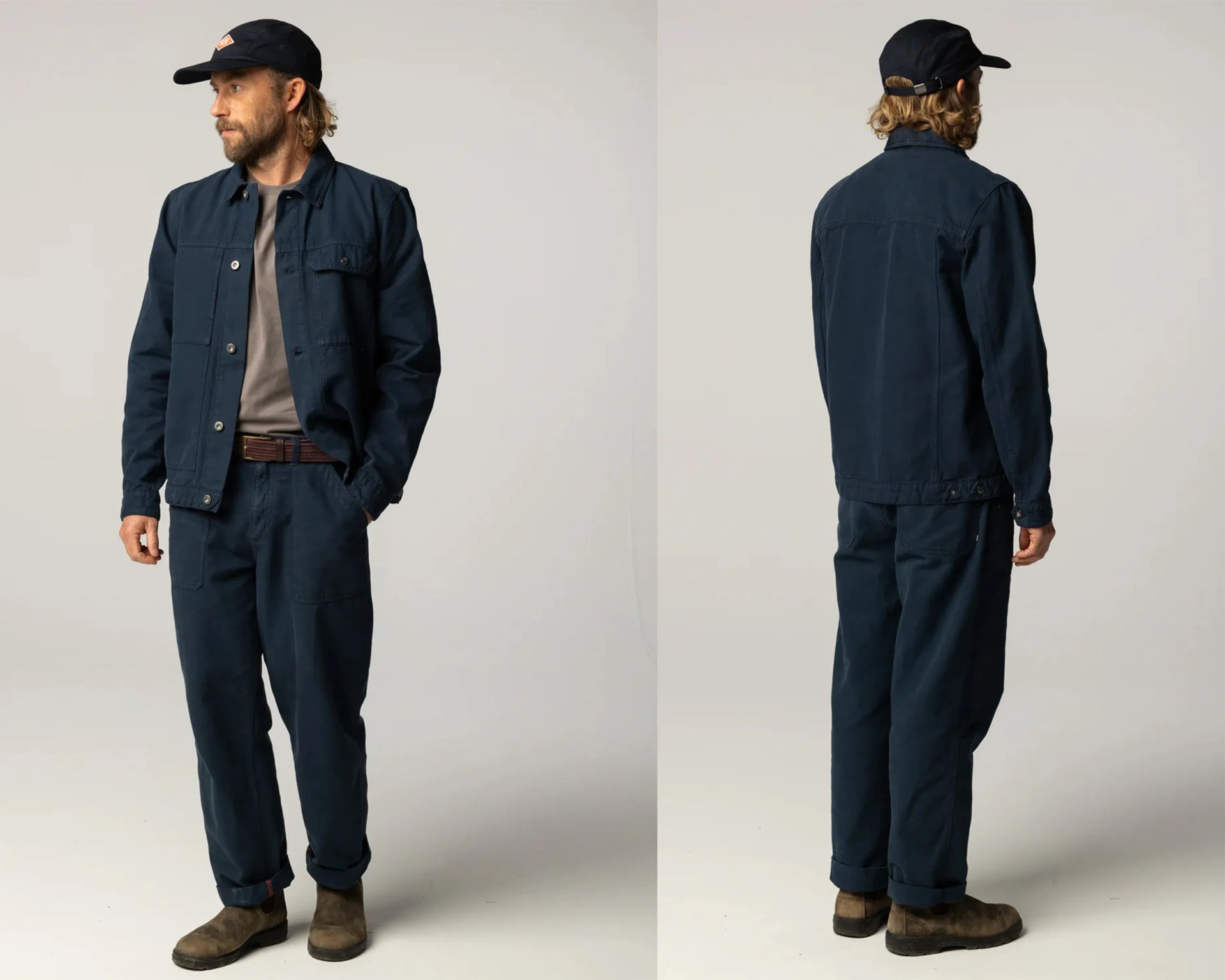 Man wearing navy blue chore jacket and matching pants with brown suede boots and black cap, shown from front and back.