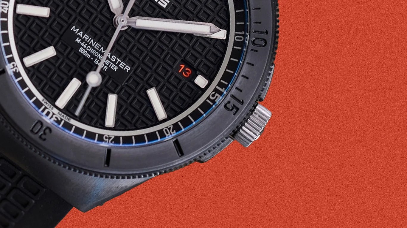 Close-up of a black Marinemaster dive watch with textured dial, white hour markers, and a date window showing 13 on an orange background.