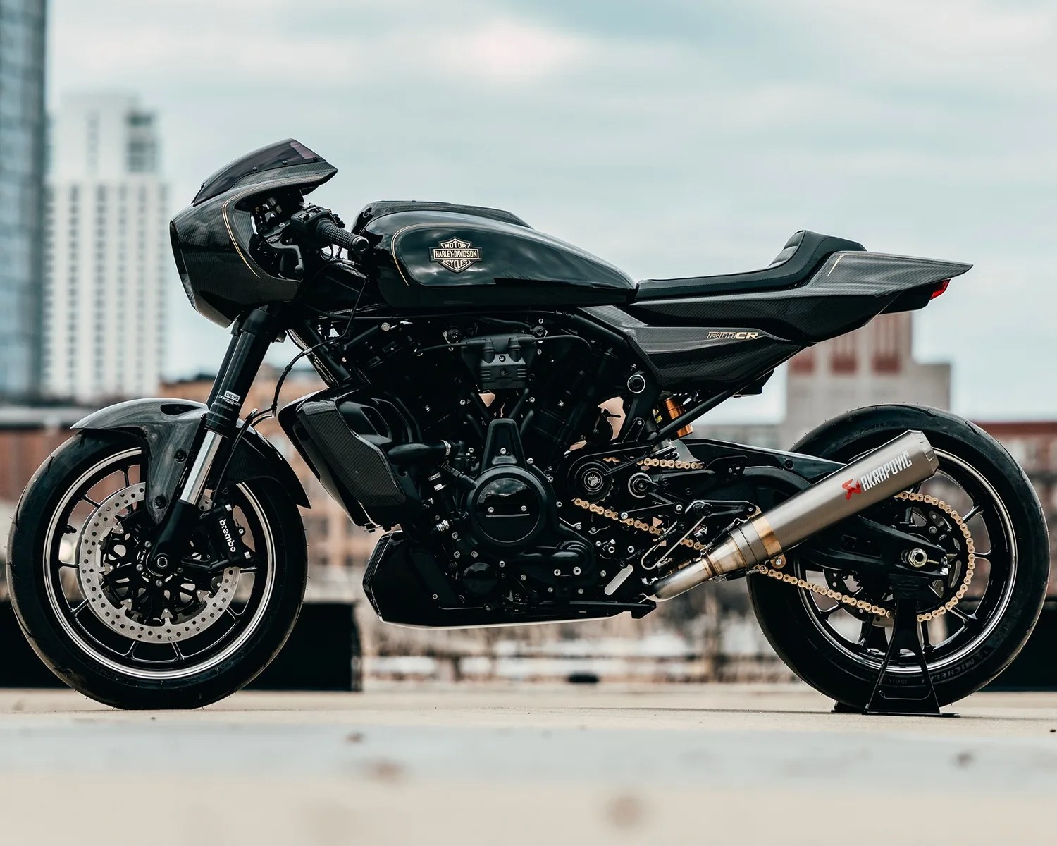 Black Harley-Davidson motorcycle with carbon fiber fairings and Akrapovic exhaust on a rooftop.