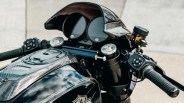 Close-up of a black Harley-Davidson motorcycle dashboard with carbon fiber details and dual round gauges.