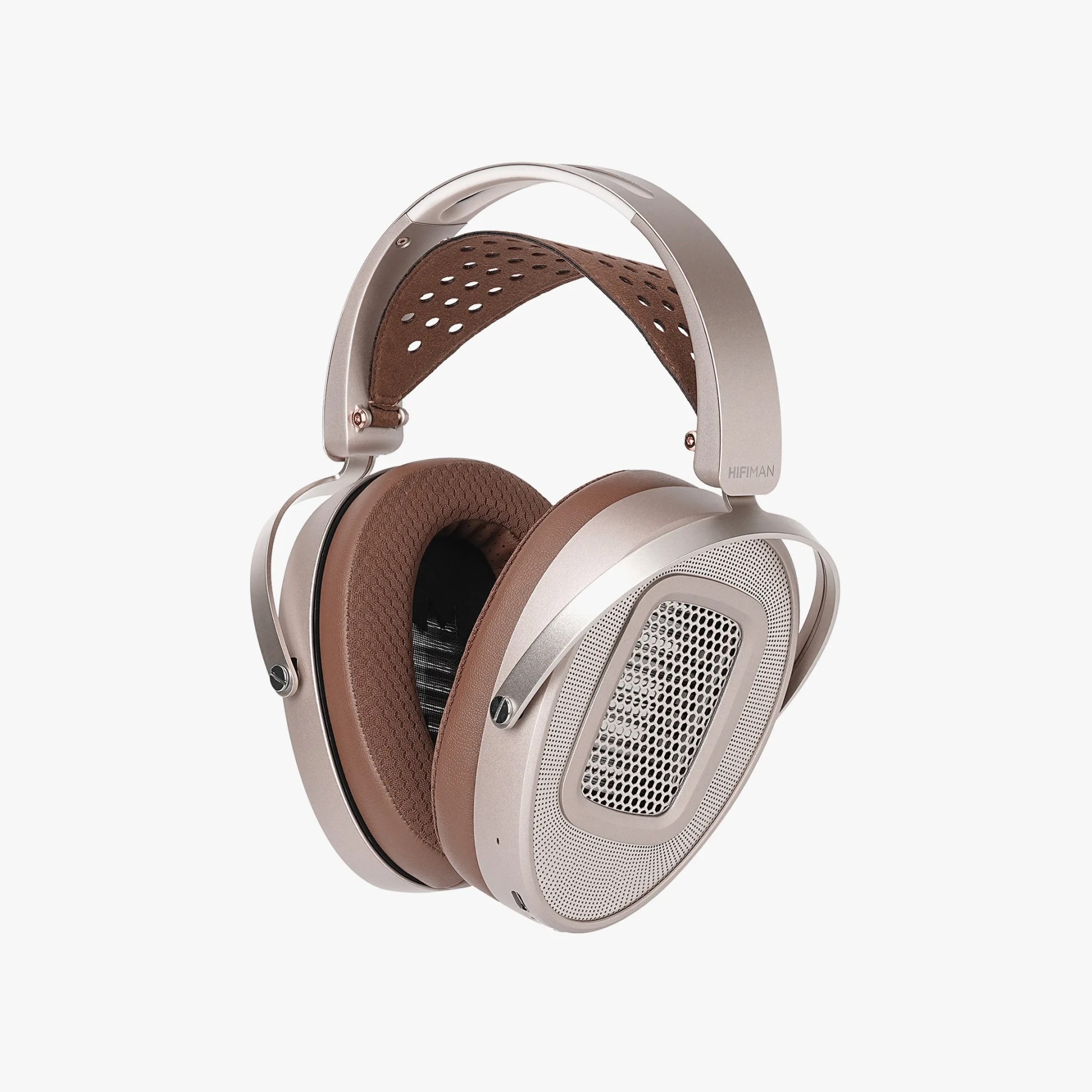 Over-ear headphones with silver metal frame and brown perforated leather headband and ear cushions.