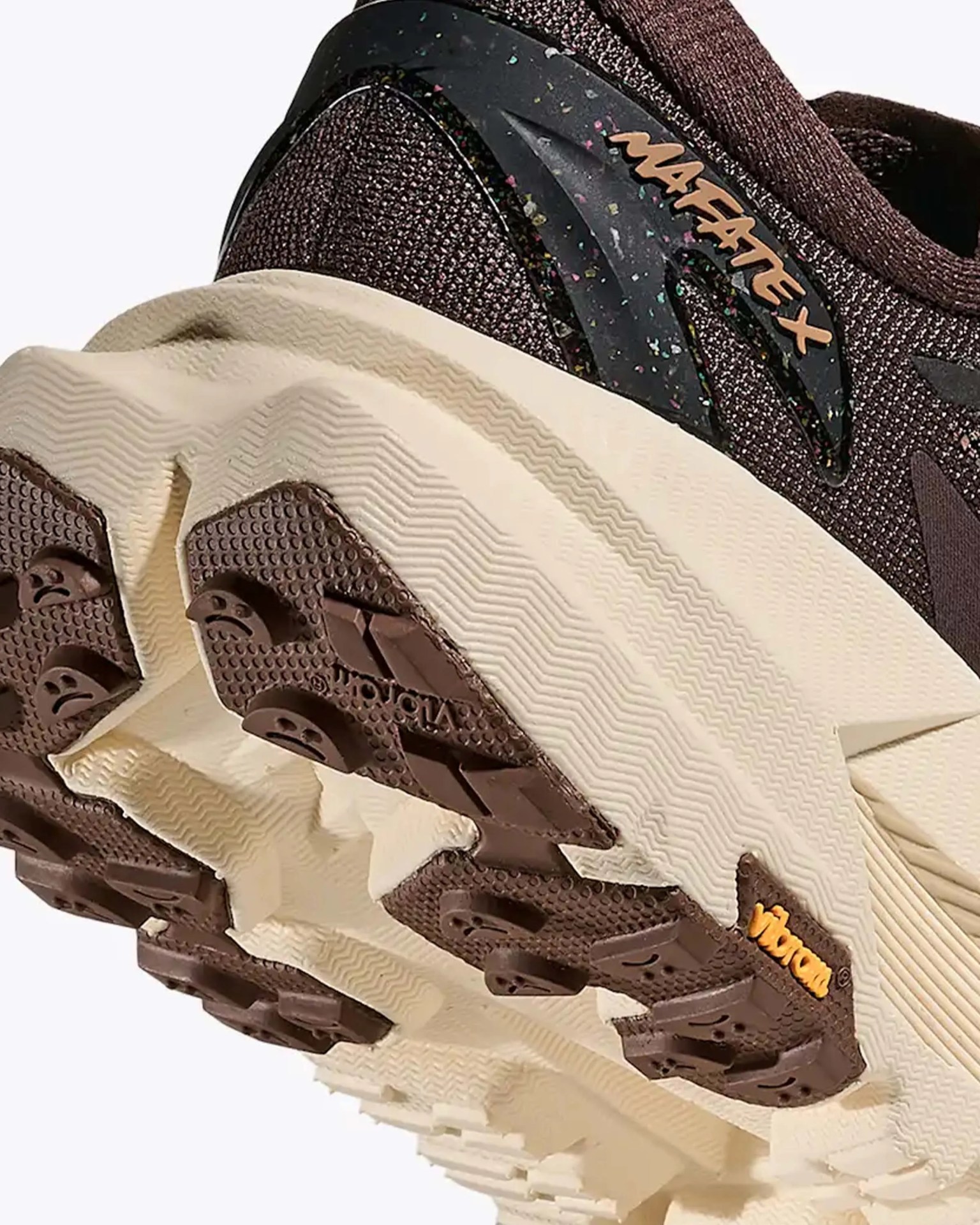 Close-up of the sole and heel of a brown and beige trail running shoe with "MAFATE X" branding and Vibram outsole.