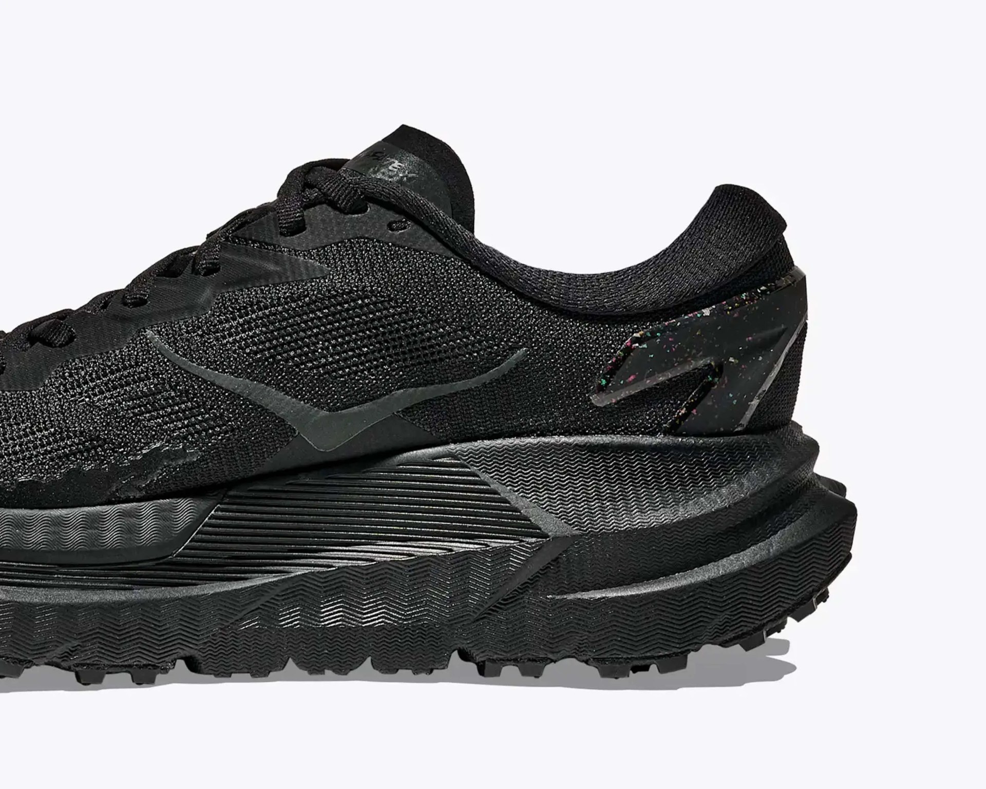 Black athletic shoe with textured knit upper, thick sculpted sole, and speckled heel counter.