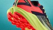 Trail running shoe with neon yellow sole and red outsole, red and black mesh upper, and yellow laces.