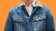 Blue denim jacket with tan corduroy collar and metal "Lee Riders" buttons worn over a striped shirt.
