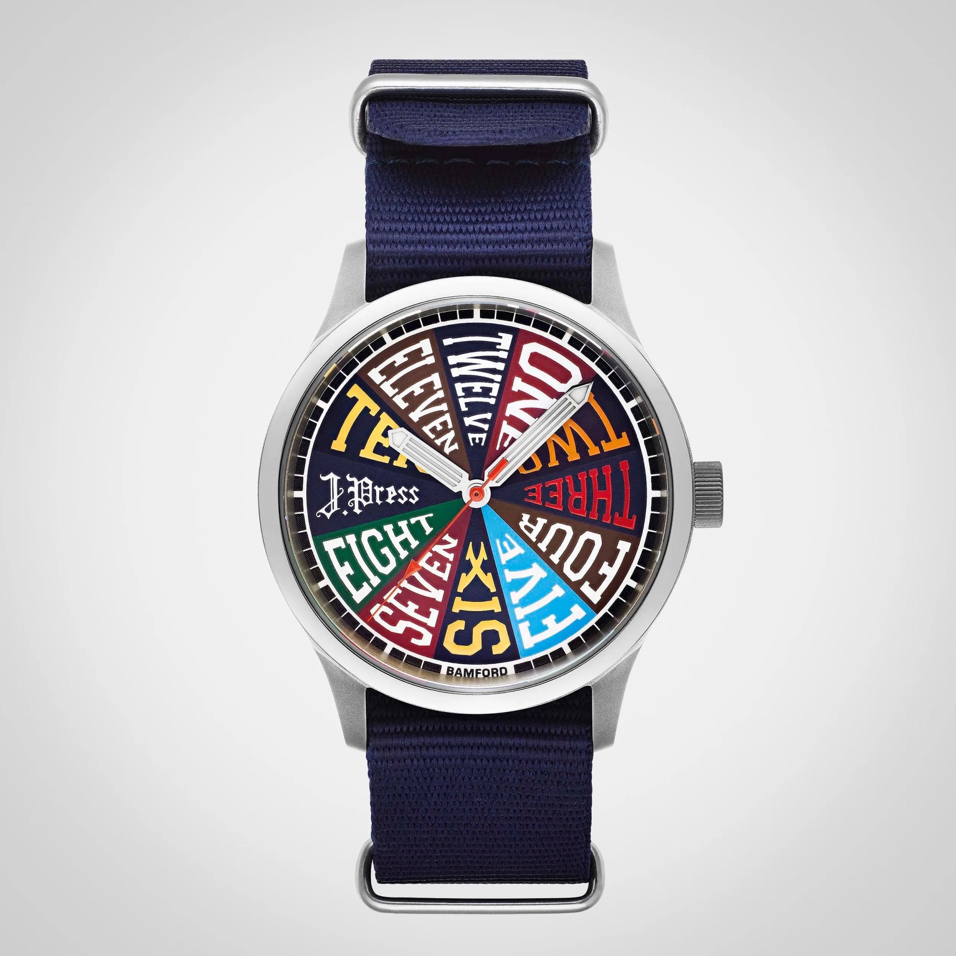 Round silver watch with a colorful dial featuring numbers spelled out in various fonts and a navy fabric strap.