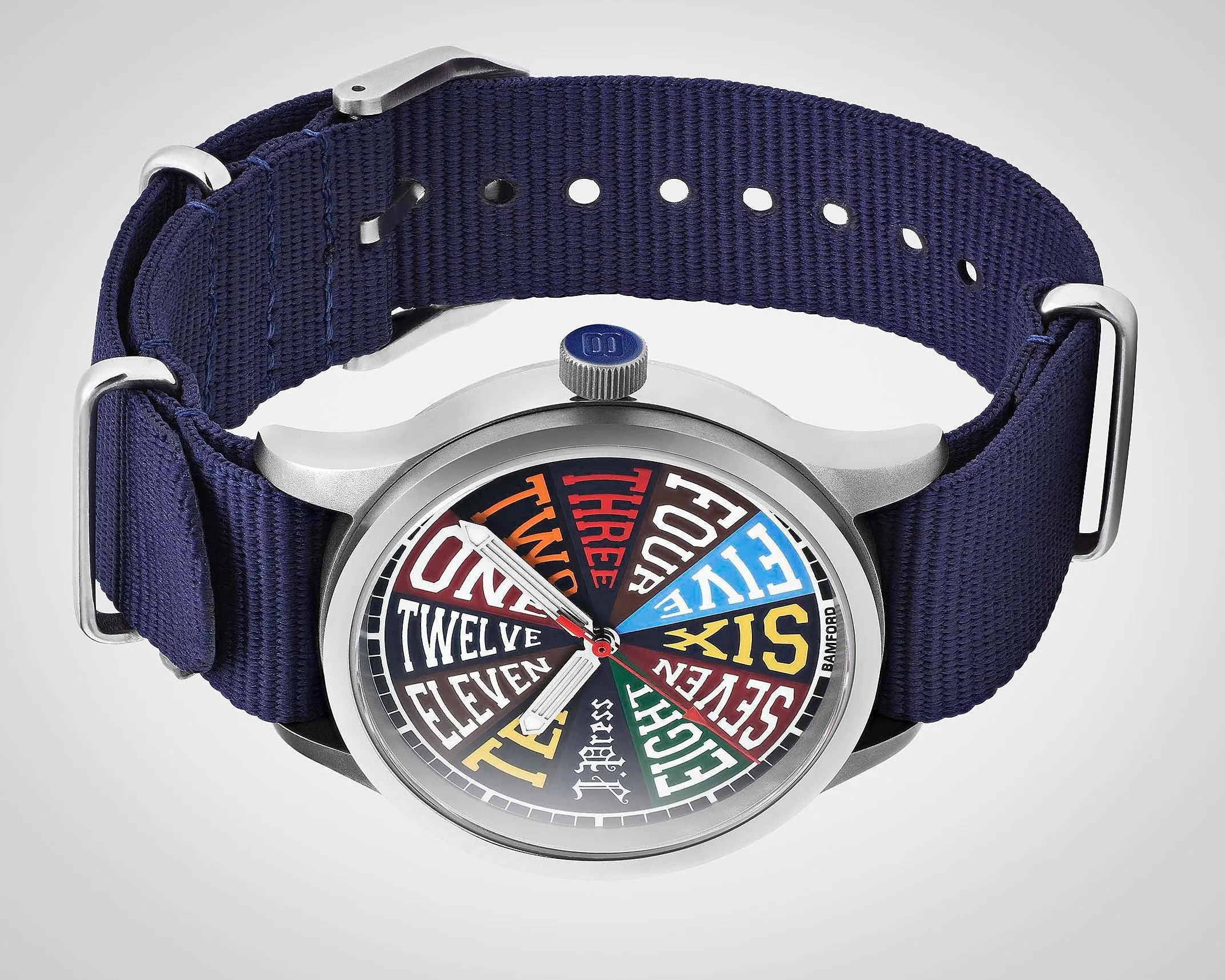 Silver wristwatch with a colorful dial displaying numbers as words and a navy blue fabric strap.