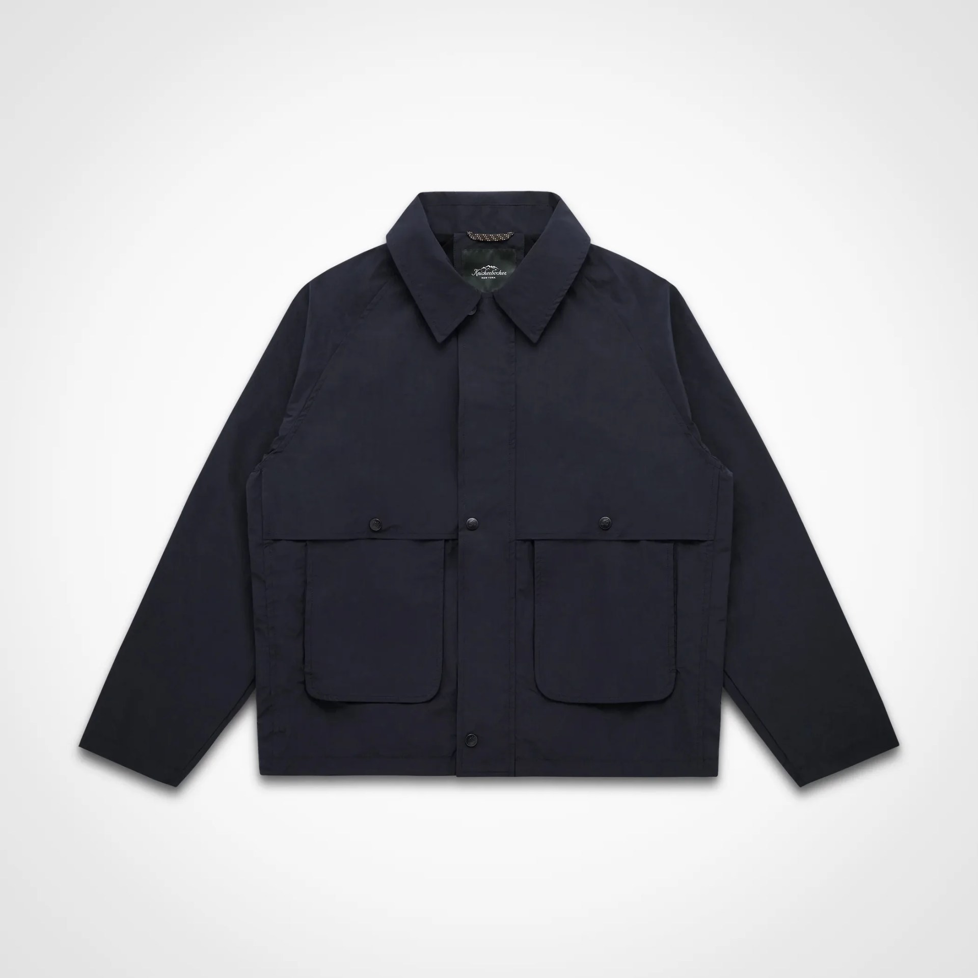 Navy blue jacket with a pointed collar and two front flap pockets with snap buttons.