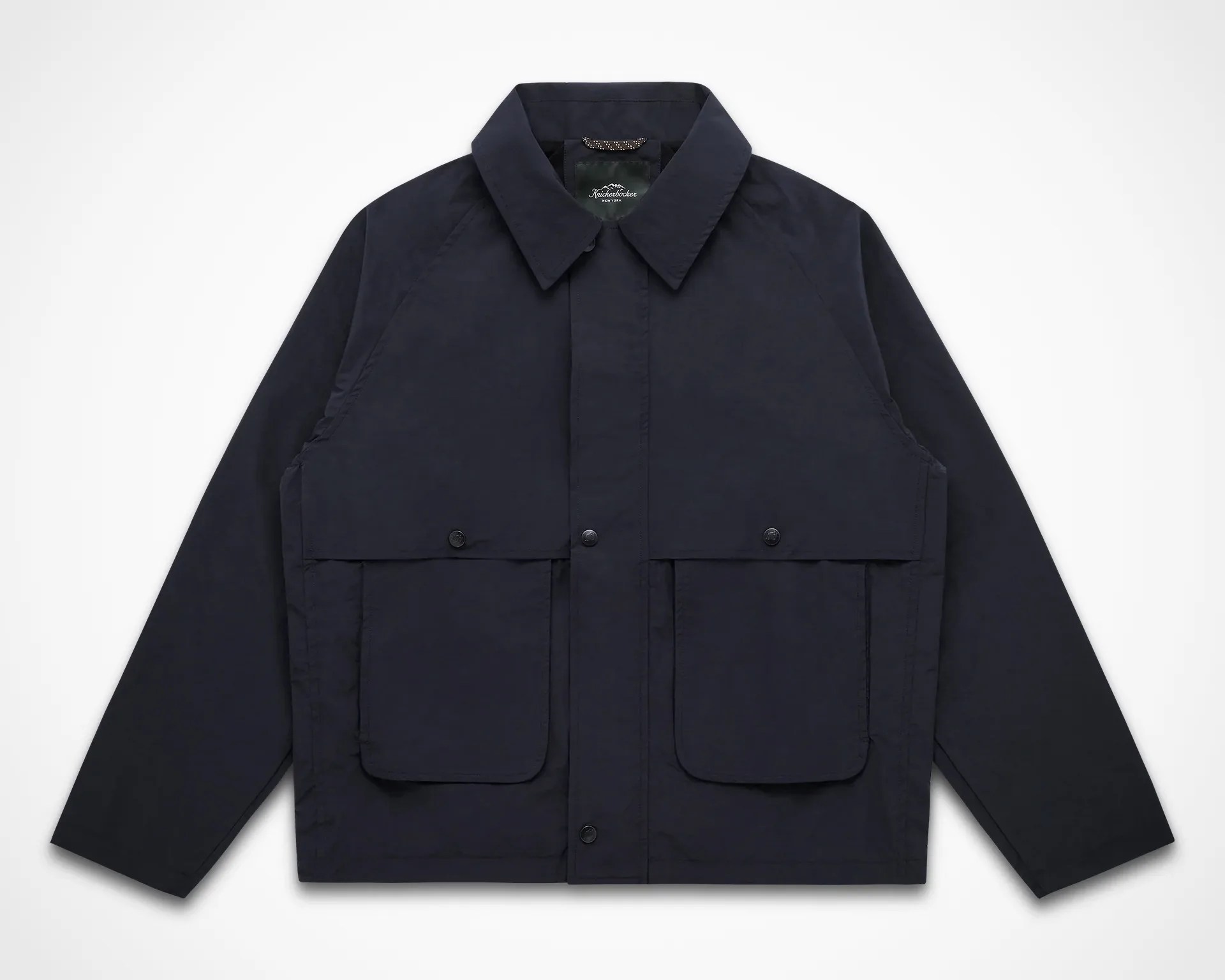 Navy blue jacket with a pointed collar and two large front flap pockets with snap buttons.