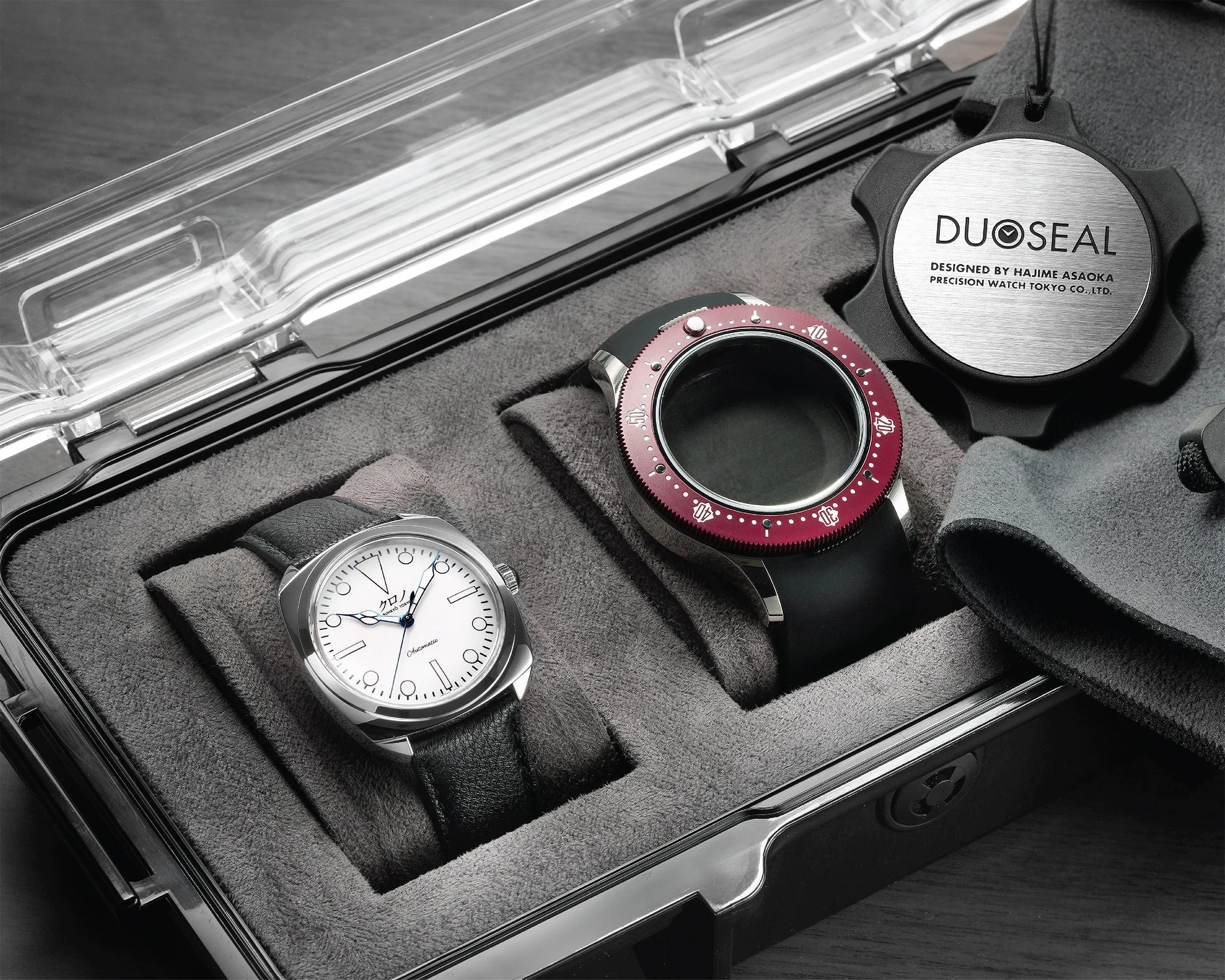 Watch repair kit with a silver watch with white dial and black leather strap, a black watch case with red bezel, and a DUOSEAL tool in a gray foam-lined plastic case.