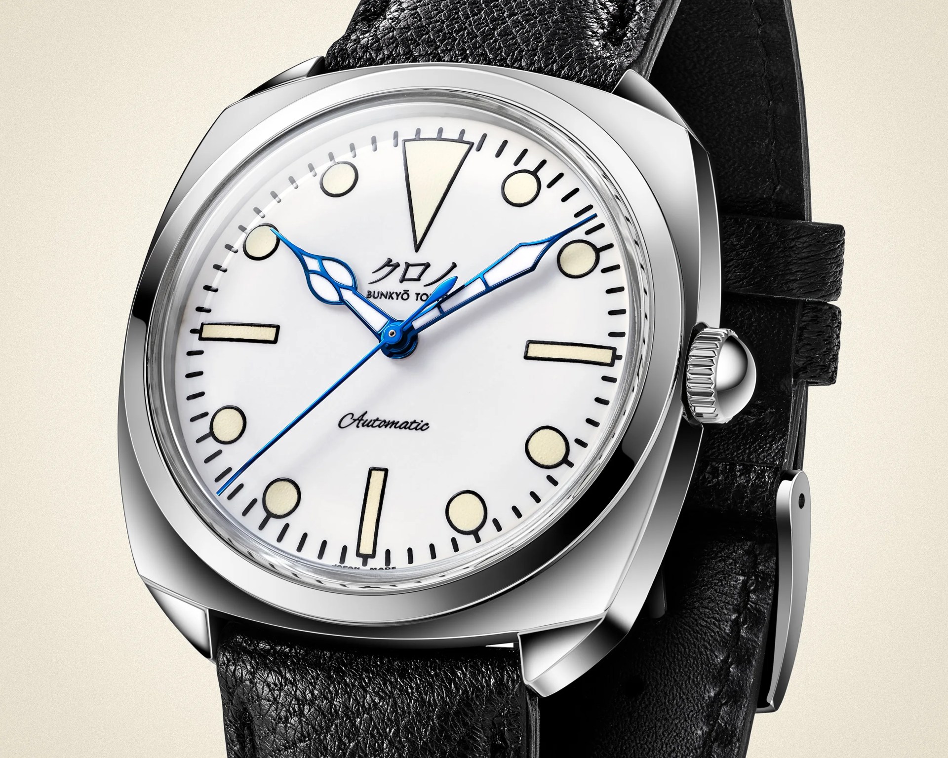 Silver automatic wristwatch with white dial, blue hands, black leather strap, and Japanese text on the face.
