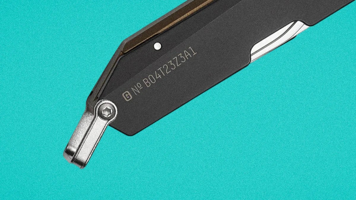 Close-up of a black and silver metal tool arm with engraved serial number B04723Z3A1 on a turquoise background.
