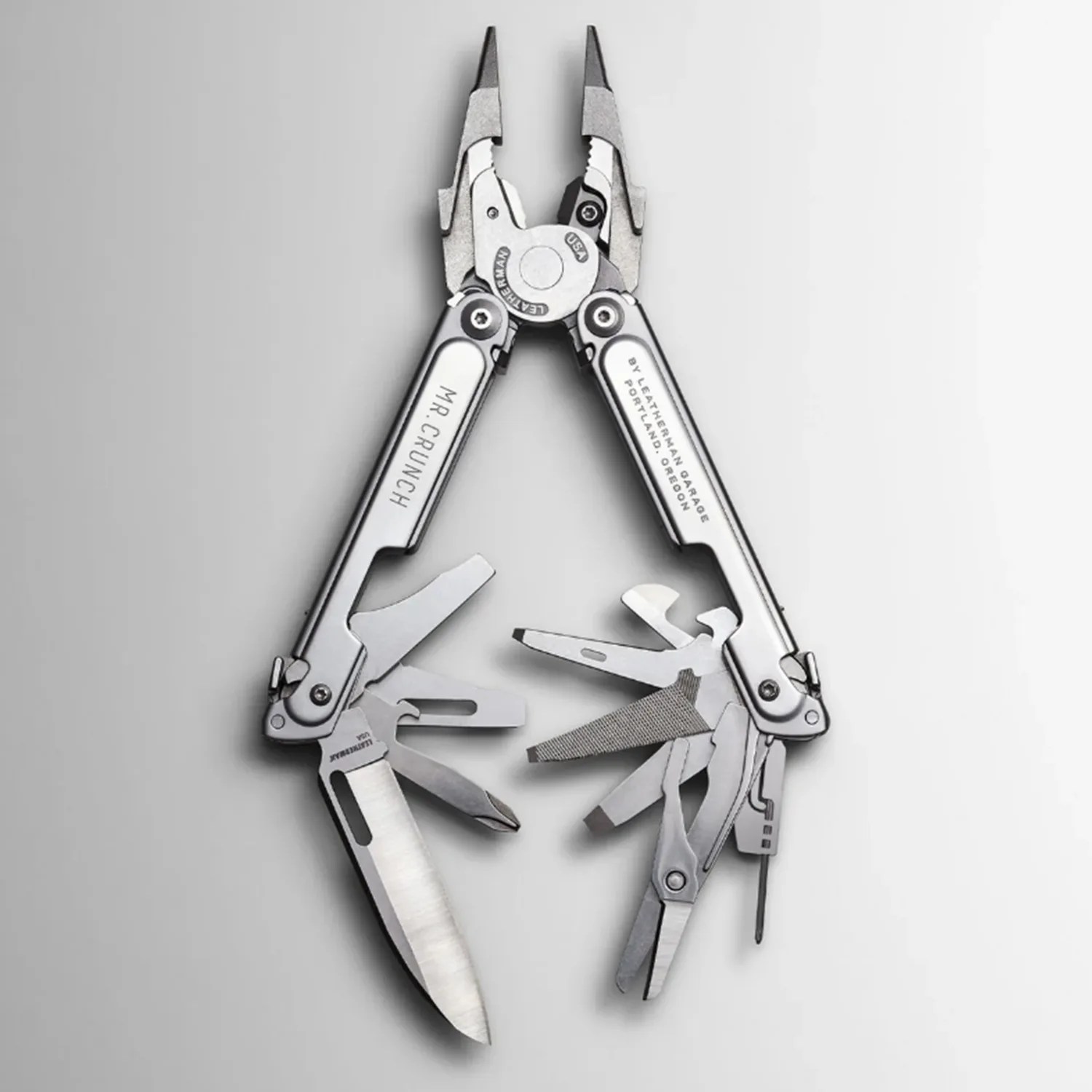 Stainless steel Leatherman multi-tool with pliers, knife, scissors, file, and other fold-out tools.