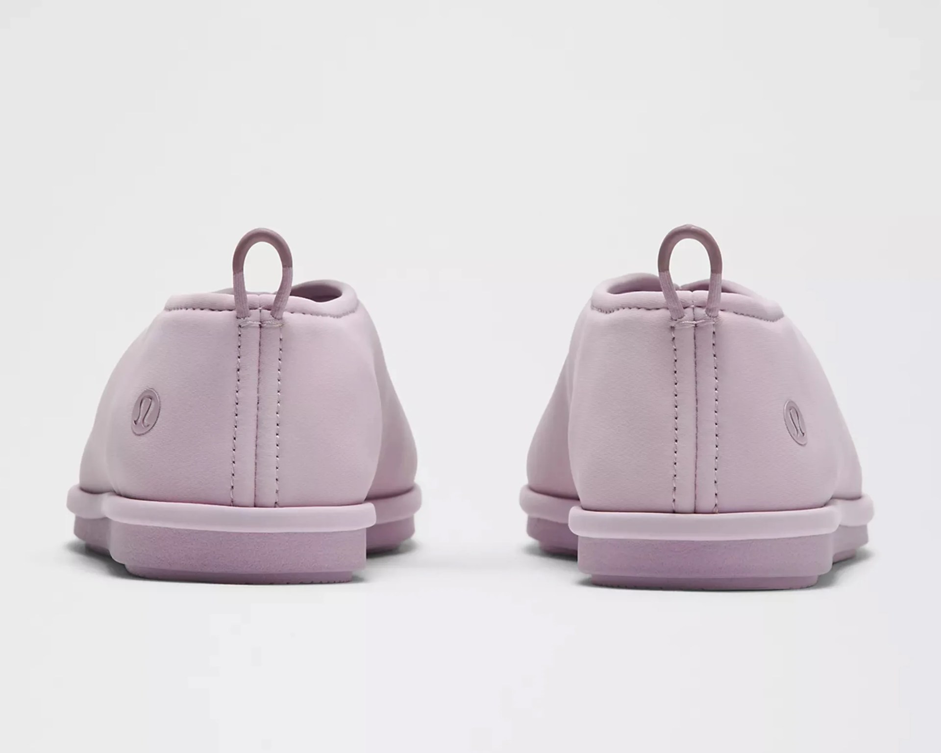 Pair of light purple slip-on shoes with pull tabs and Lululemon logos on the heels.