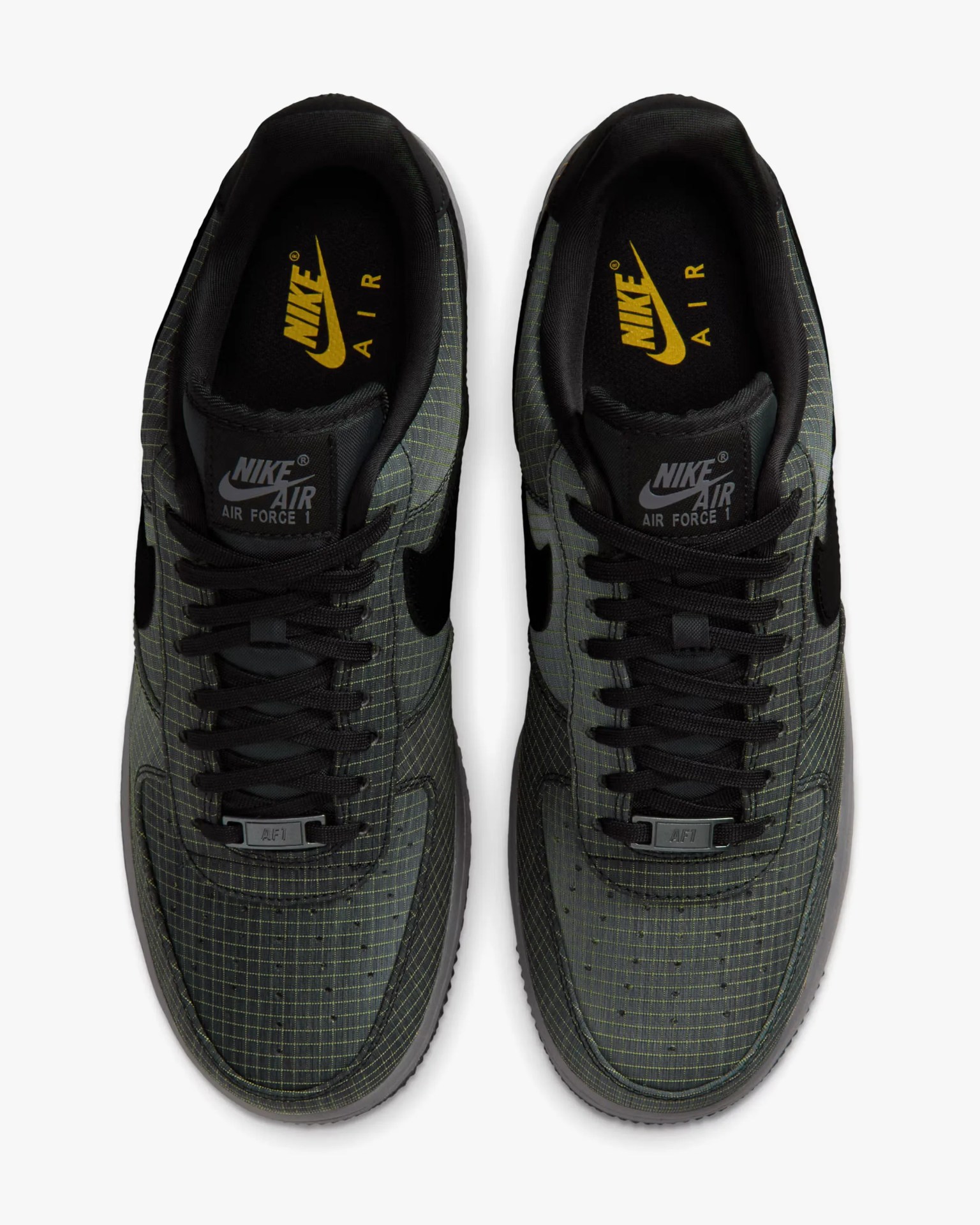 Pair of black and dark green Nike Air Force 1 sneakers with grid pattern and black laces, viewed from above.