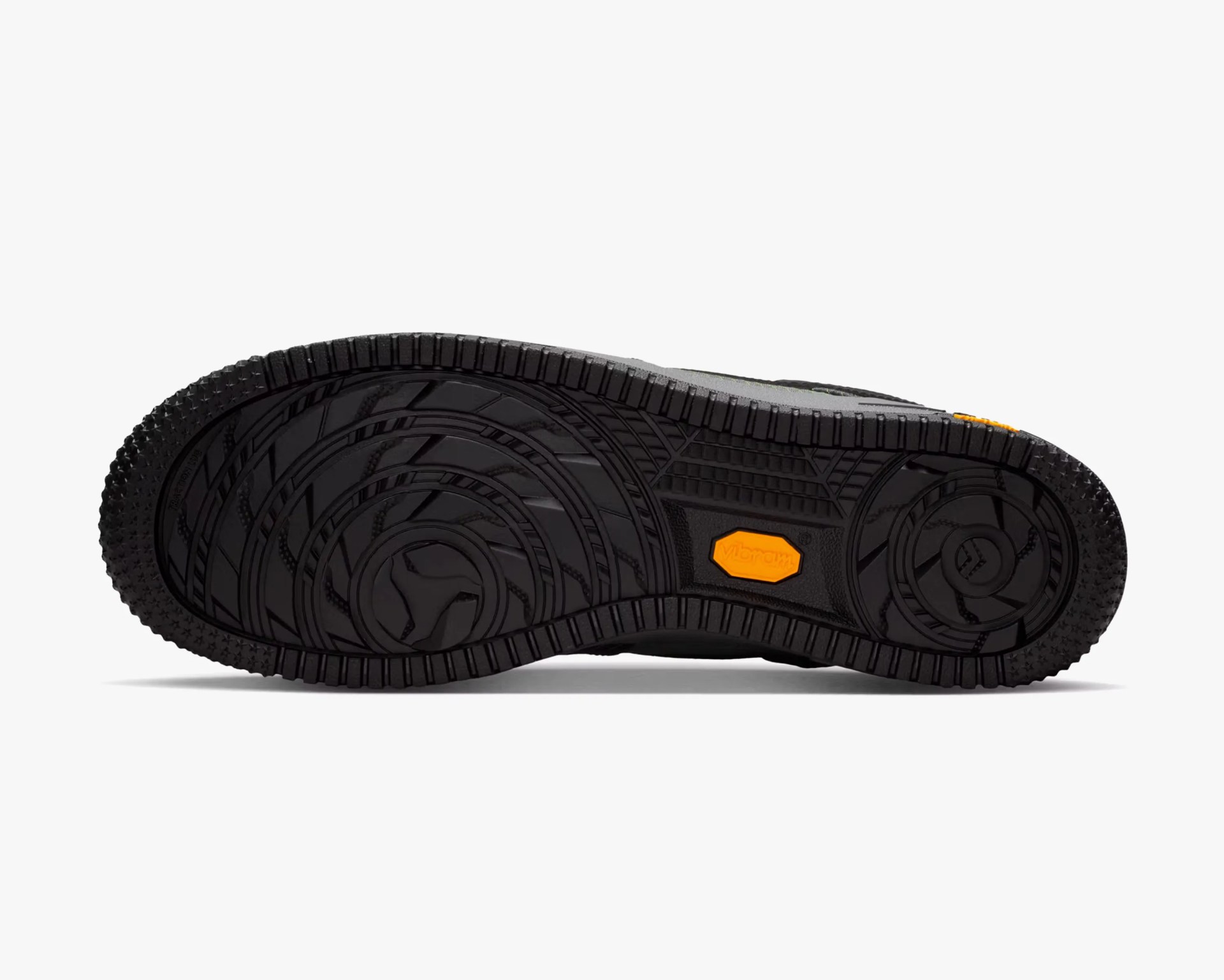 Black rubber shoe sole with circular tread patterns and an orange Vibram logo in the center.