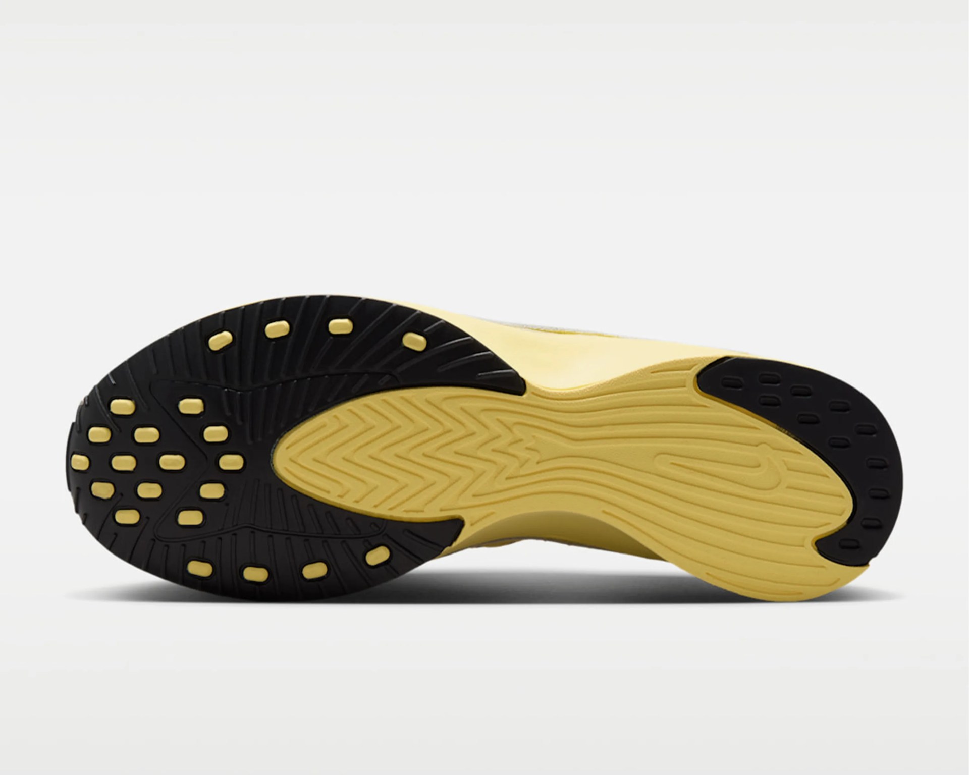 Yellow and black rubber outsole of a Nike shoe with textured grip and a small Nike swoosh logo.