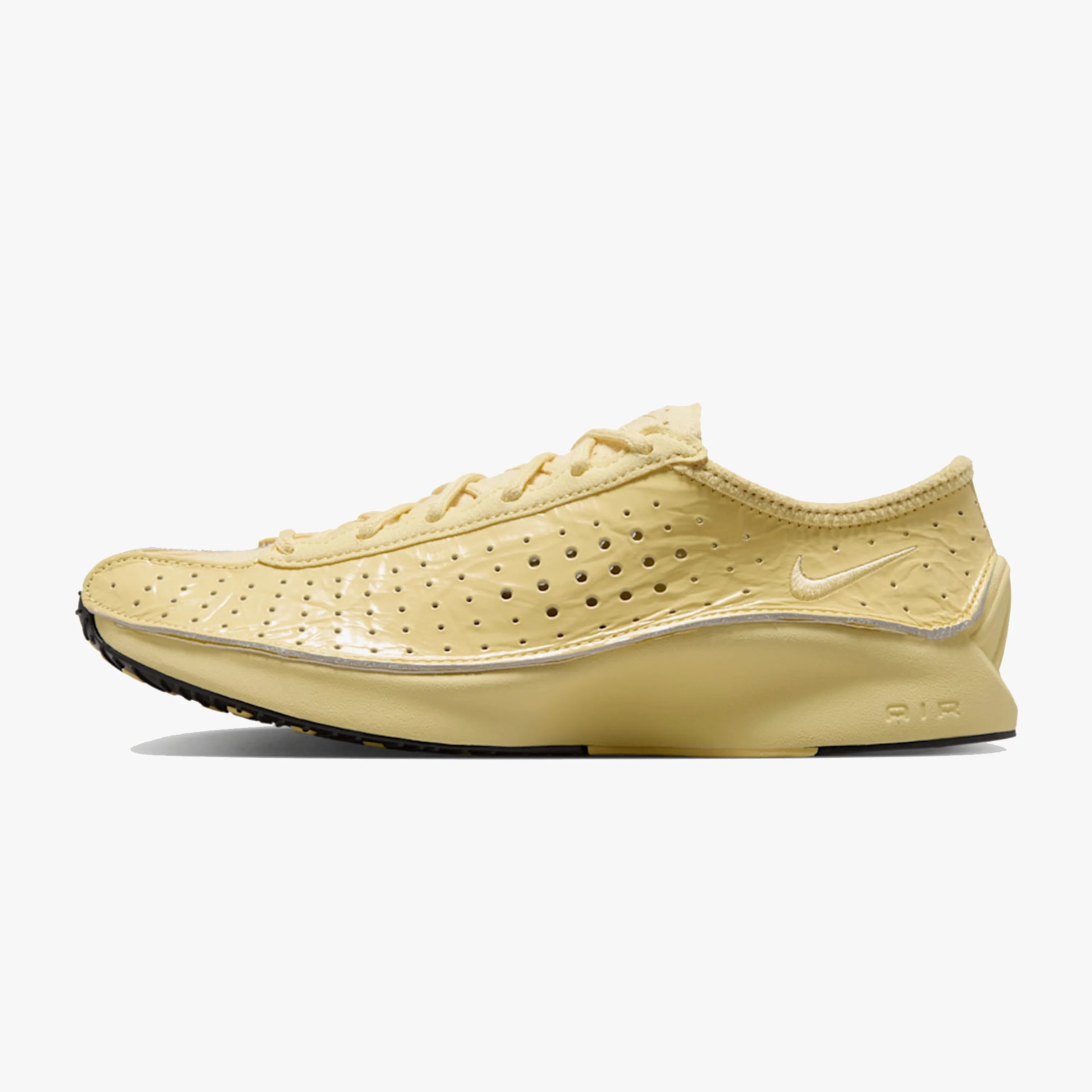 Light yellow Nike running shoe with perforated upper and black sole viewed from the side.