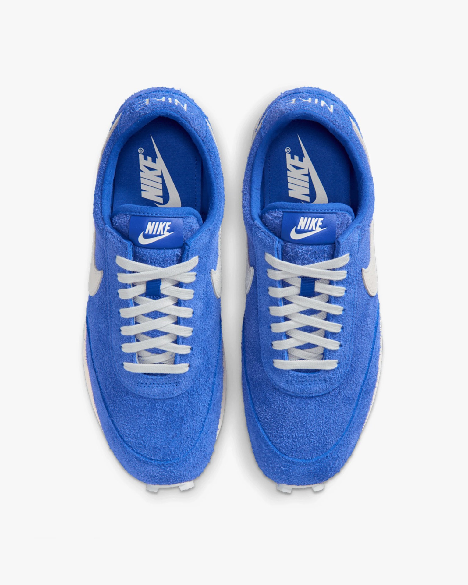 Pair of blue Nike sneakers with white laces and white Nike swoosh logos, viewed from above.