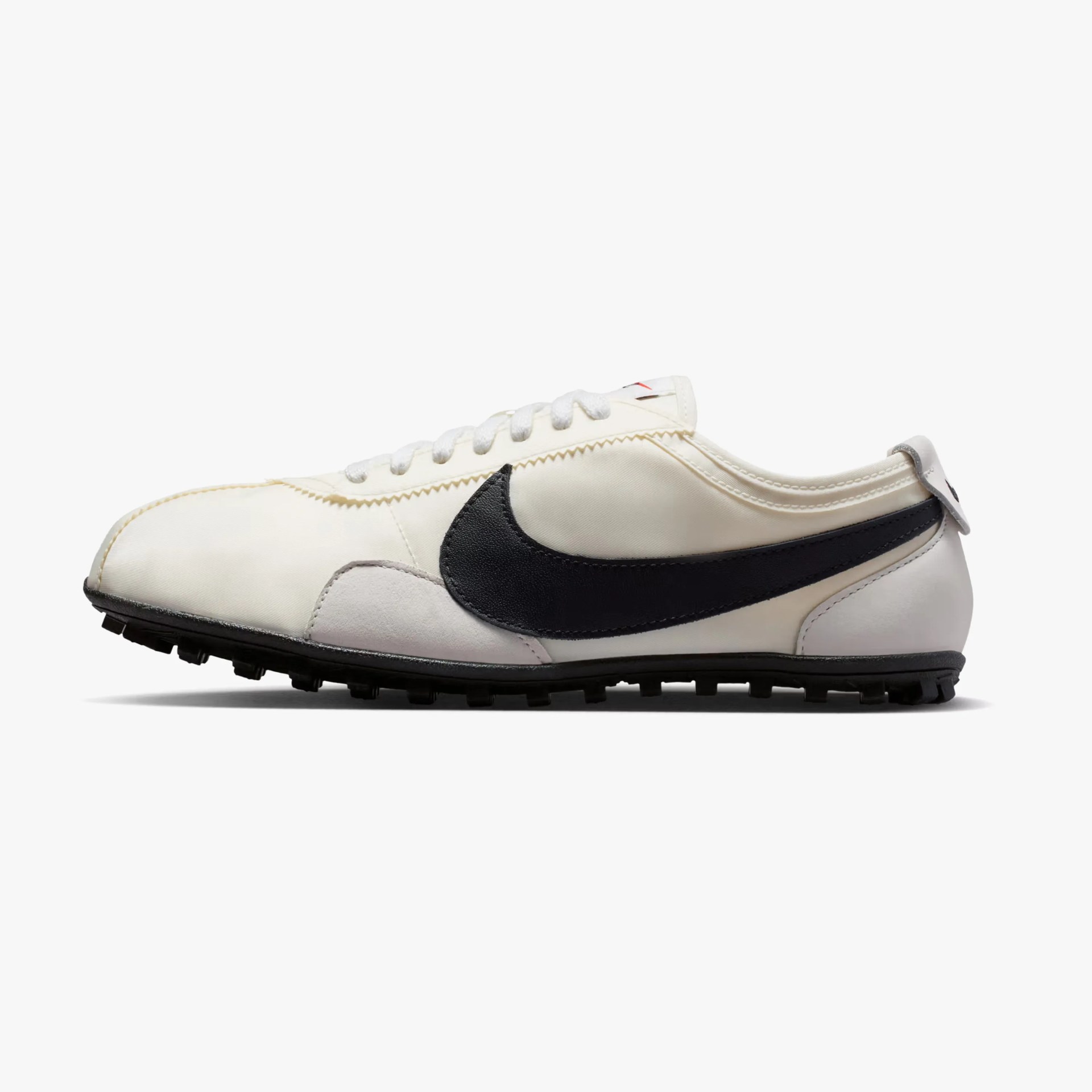 White and light gray Nike sneaker with a large black swoosh and black sole, shown in side profile.