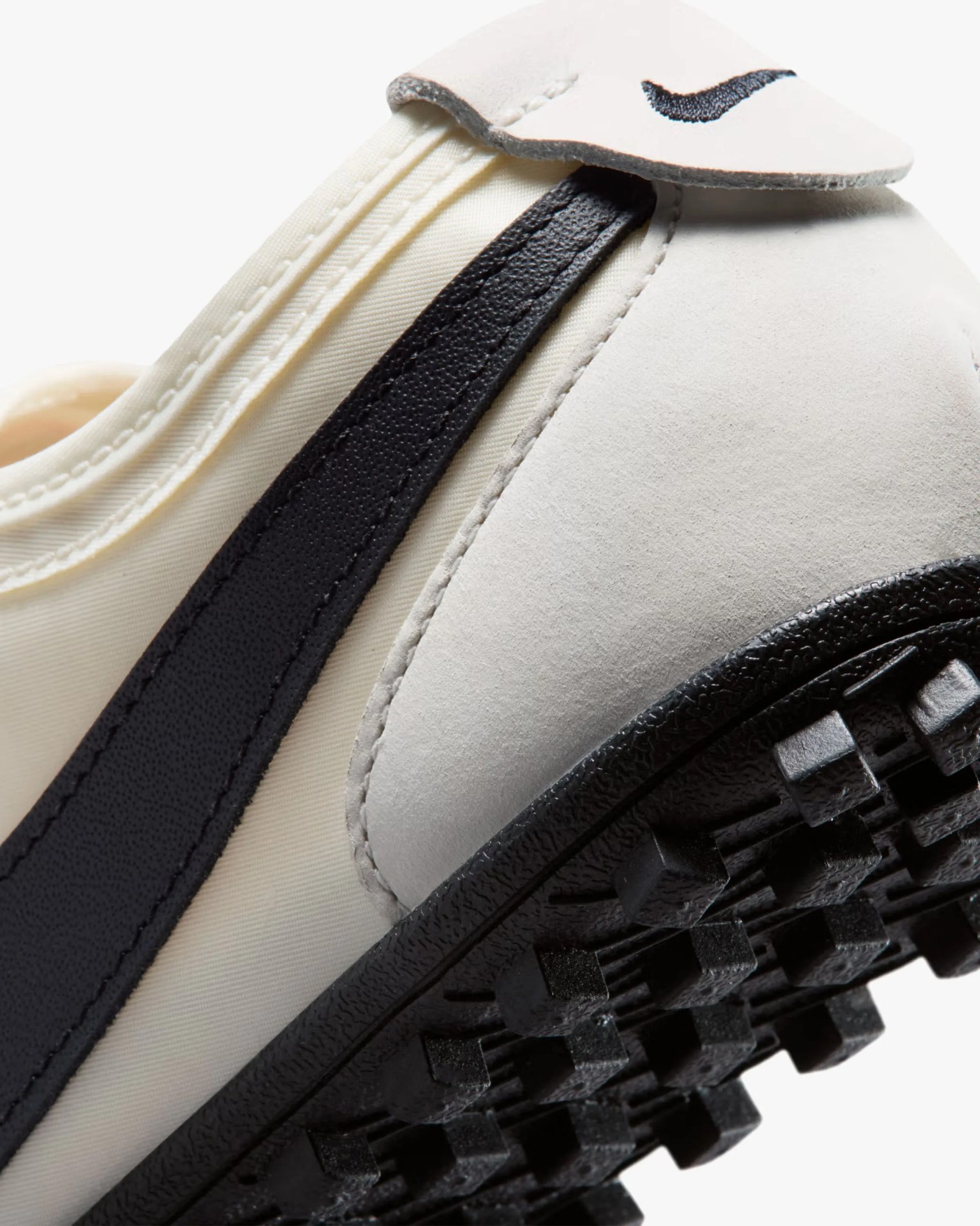 Close-up of the heel and sole of a white and black Nike sneaker with a textured black outsole.
