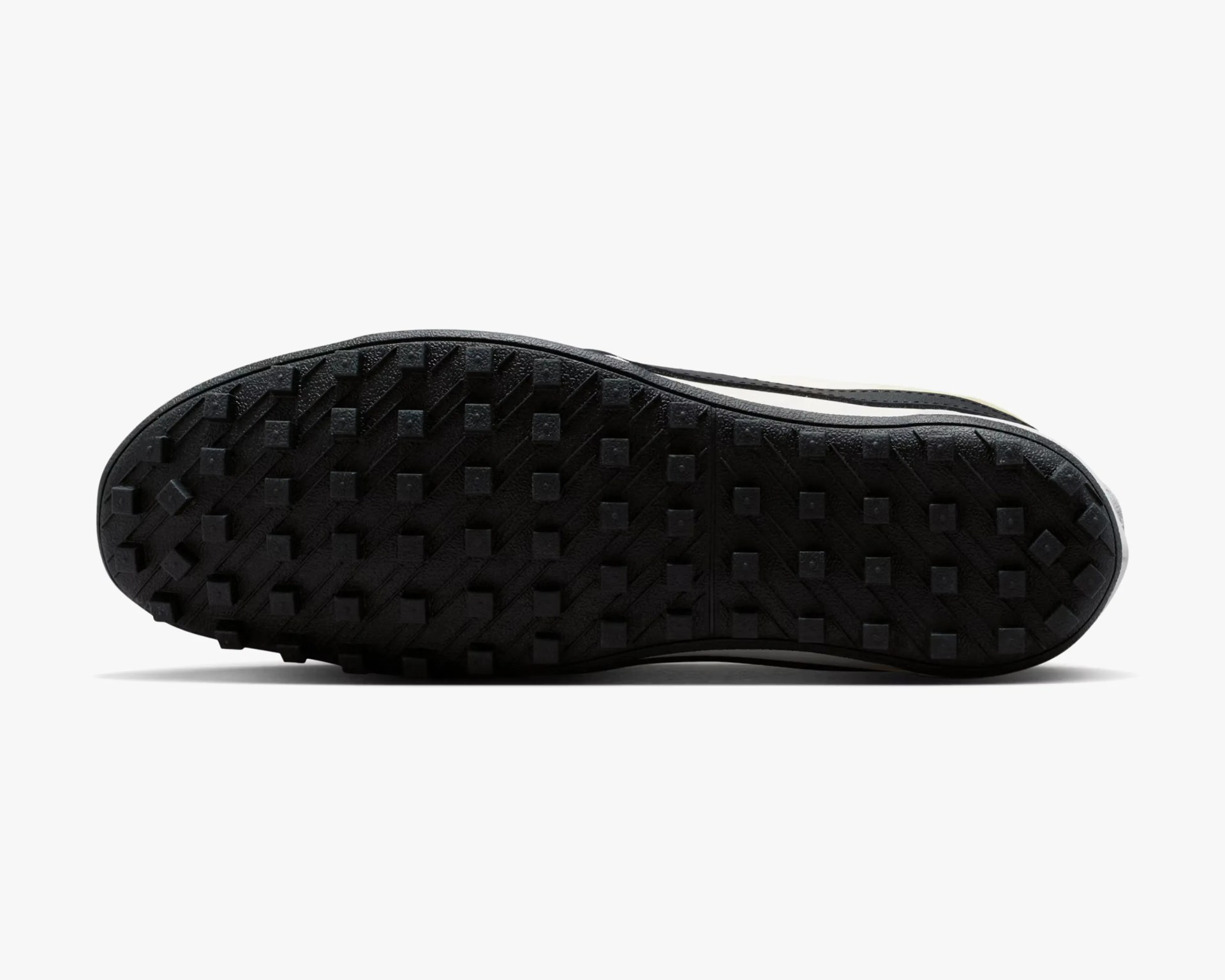 Black rubber shoe sole with square-shaped traction studs in a grid pattern.