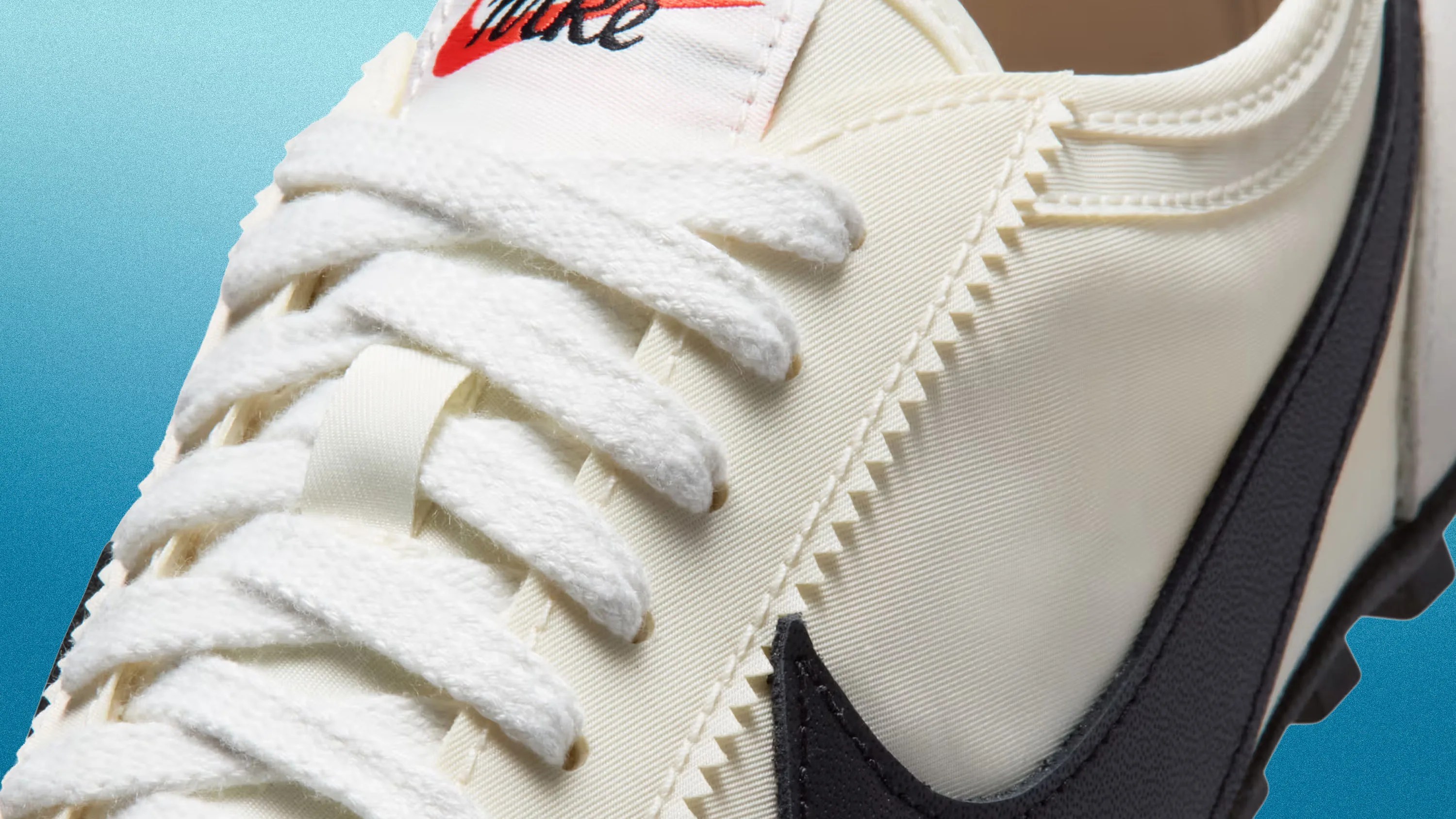 Close-up of cream-colored Nike sneaker with white laces and black swoosh logo on a blue gradient background.