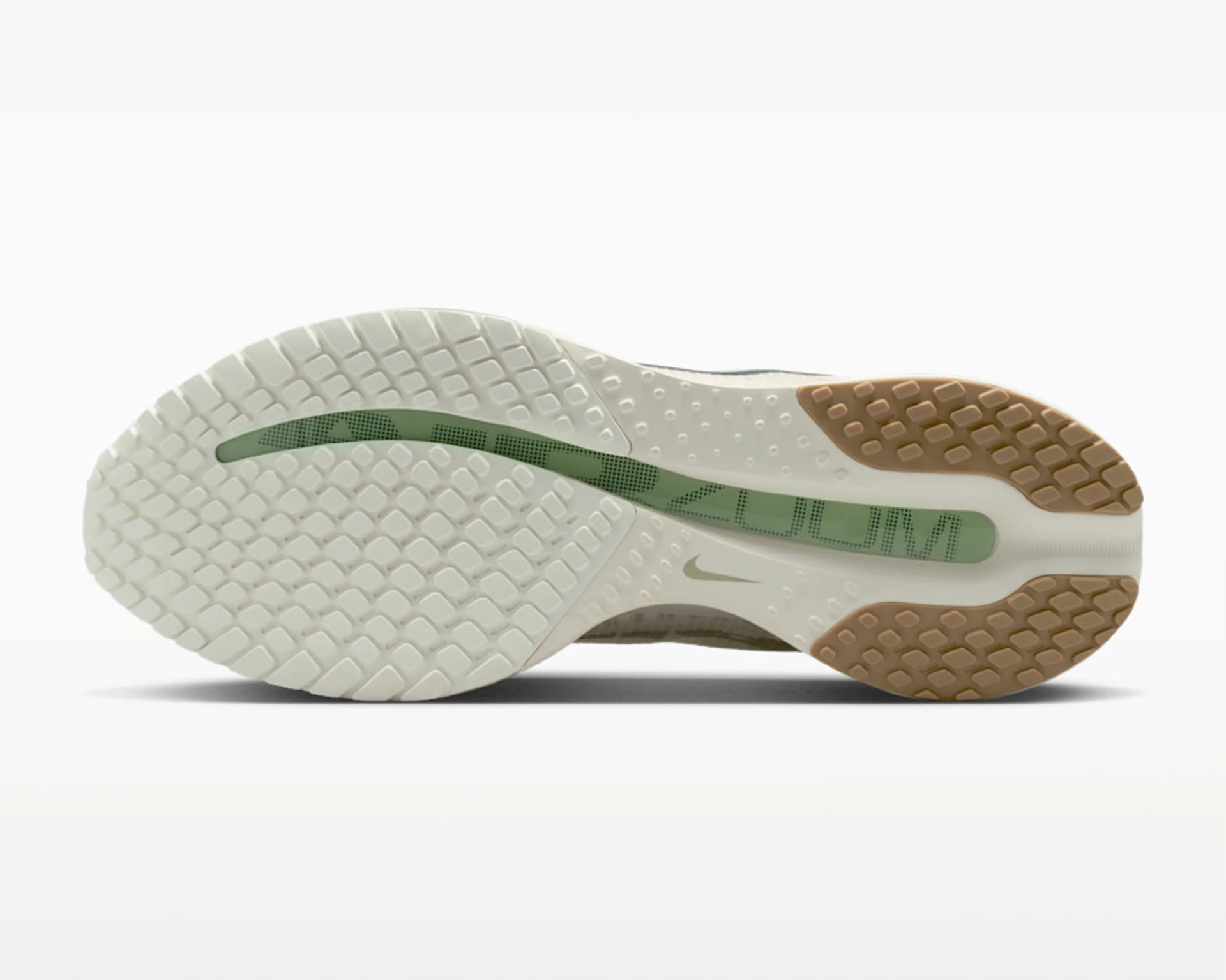 White and tan rubber outsole of a Nike Zoom running shoe with green "ZOOM" text visible through a translucent section.