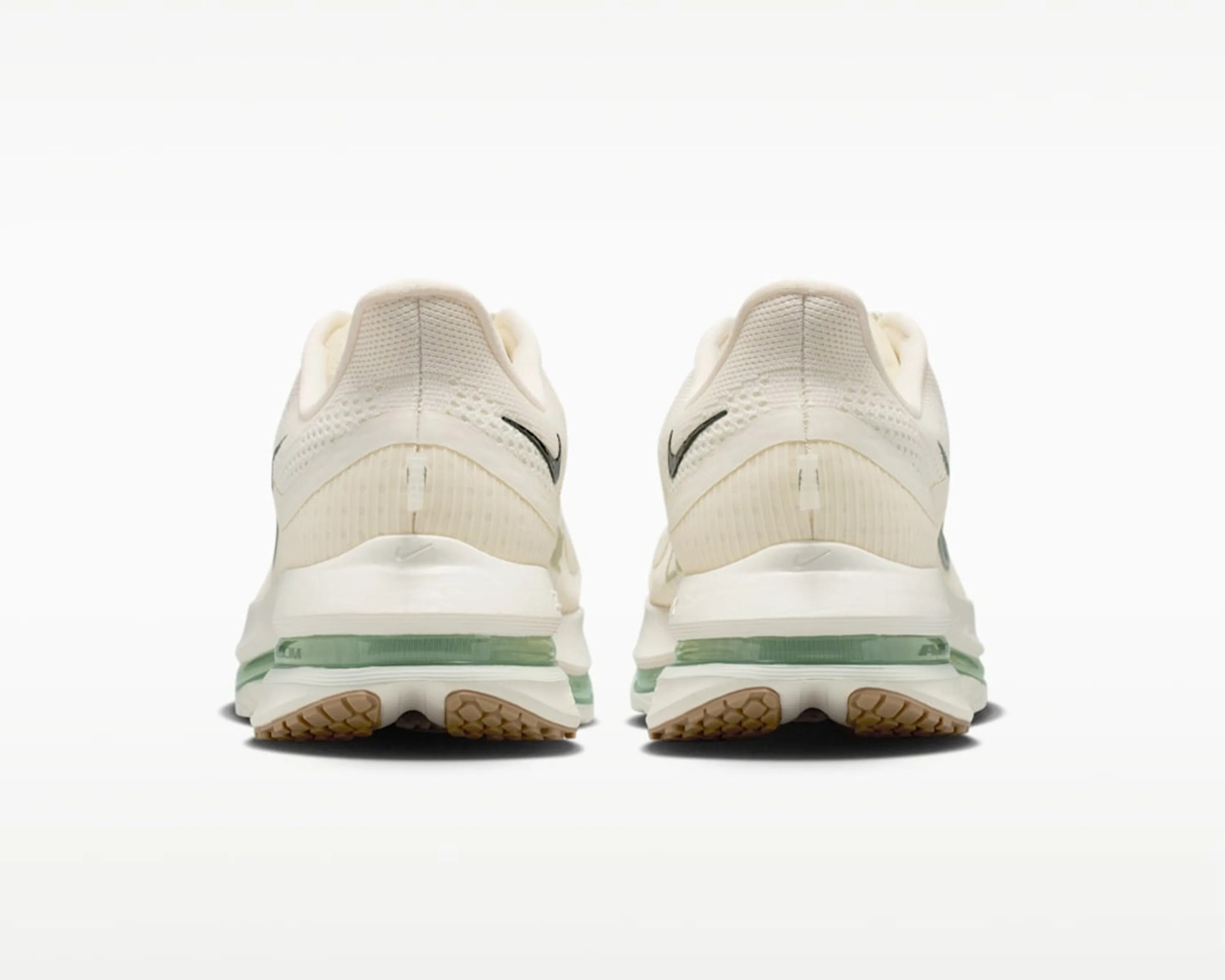 Pair of off-white Nike running shoes with green air cushion soles shown from the back.