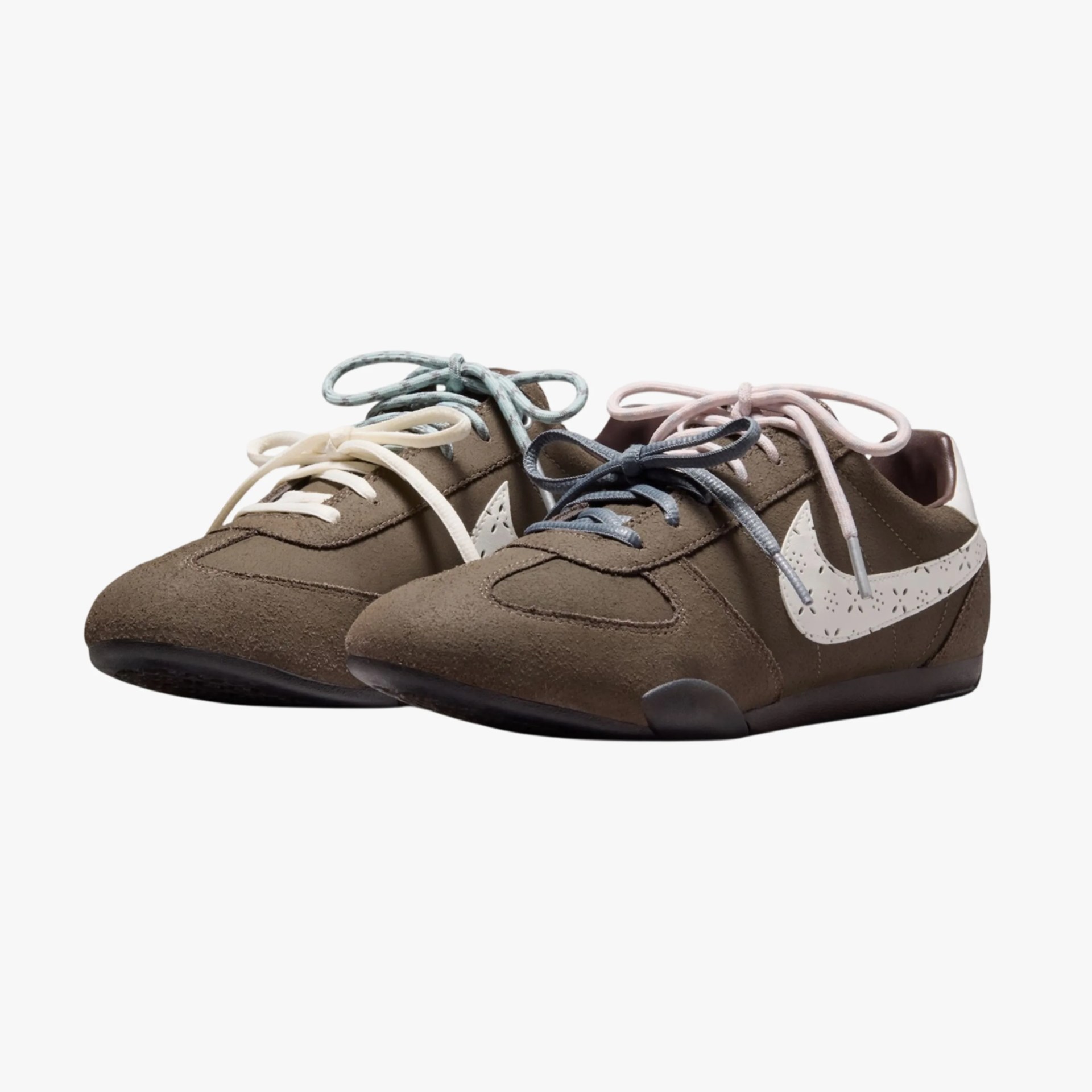 Pair of brown suede Nike sneakers with white perforated swooshes and mismatched pastel-colored laces.