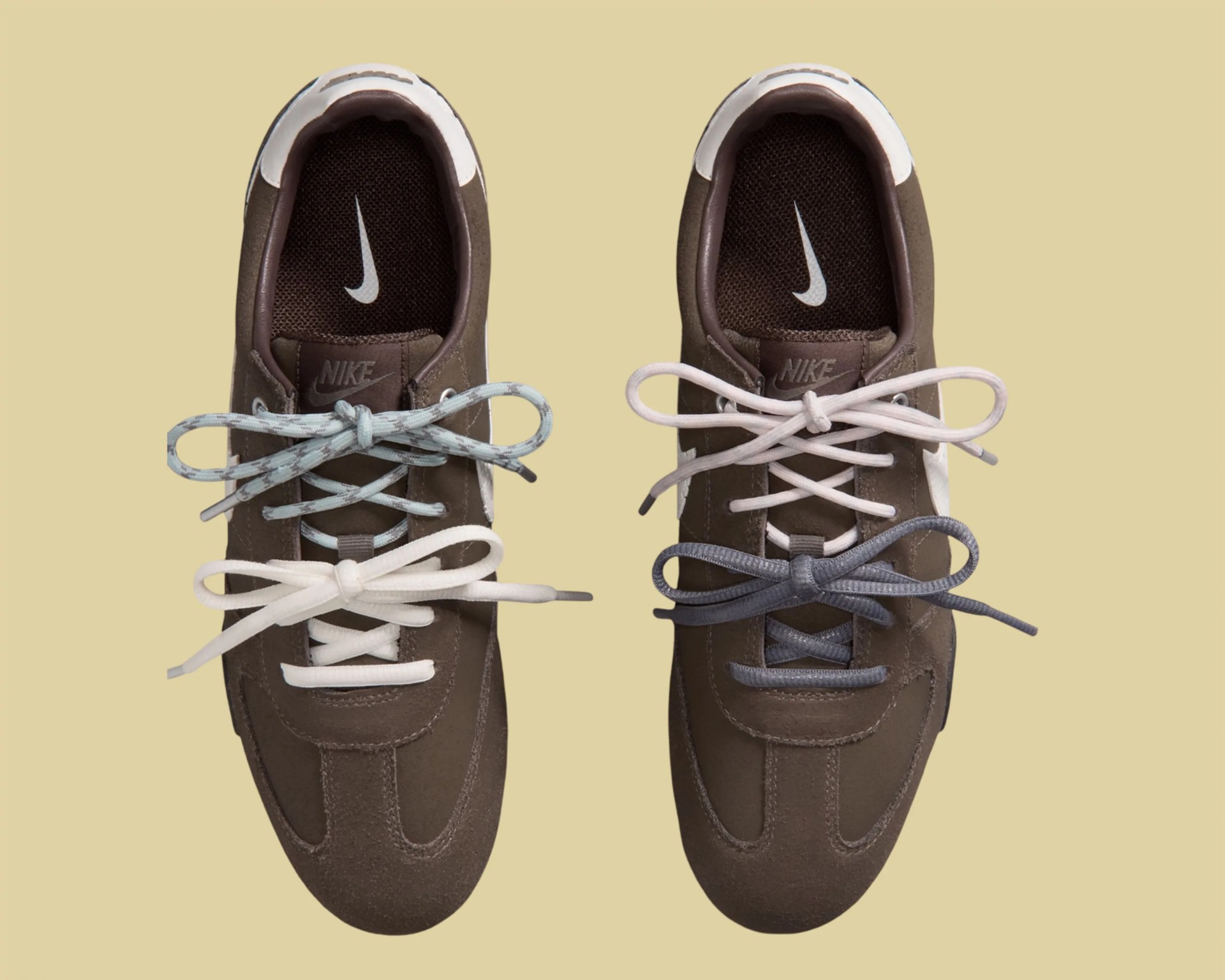 Pair of brown Nike sneakers with white soles, each shoe featuring two different colored laces tied in bows.