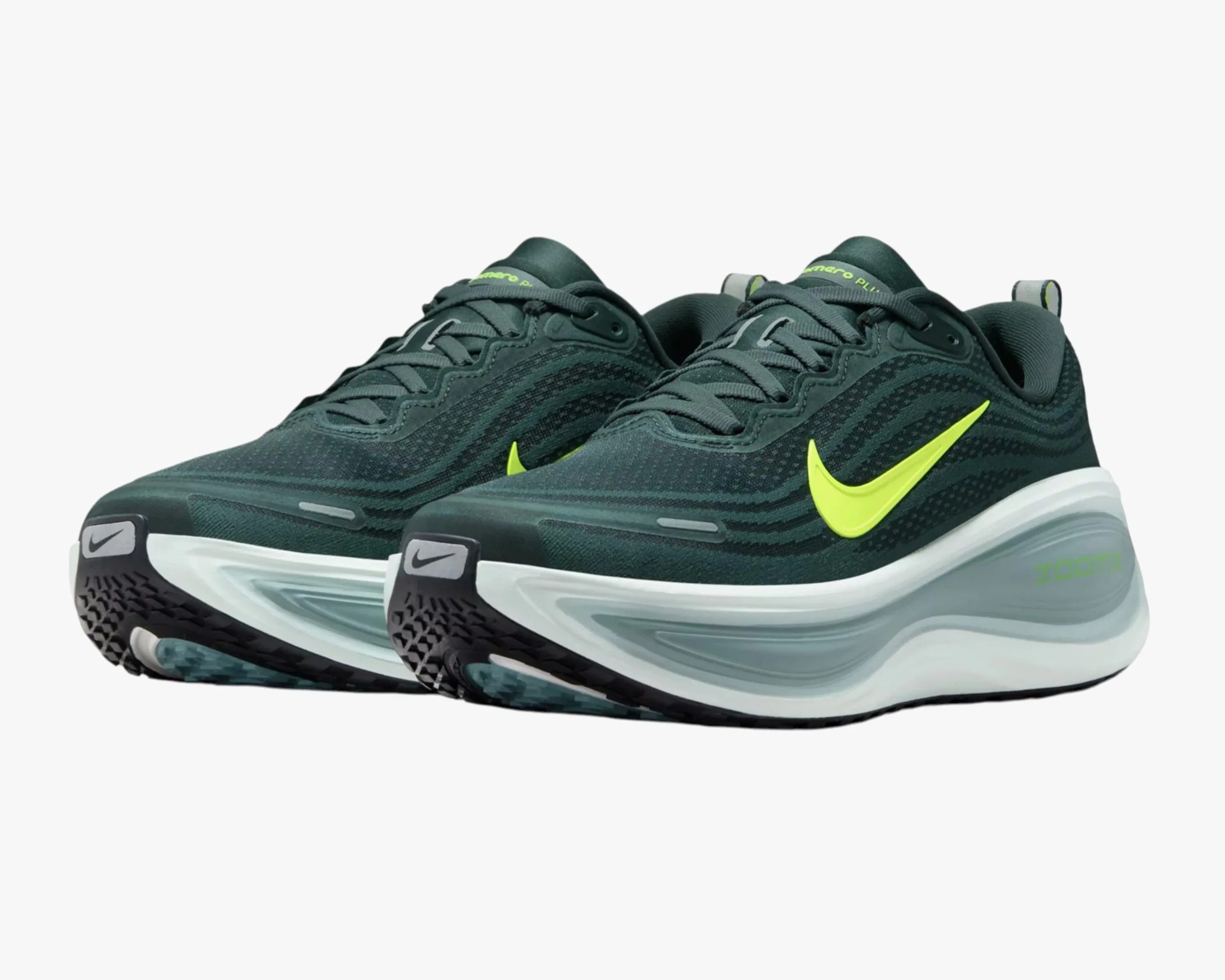 Pair of dark green Nike running shoes with neon yellow swoosh and thick white and gray soles.