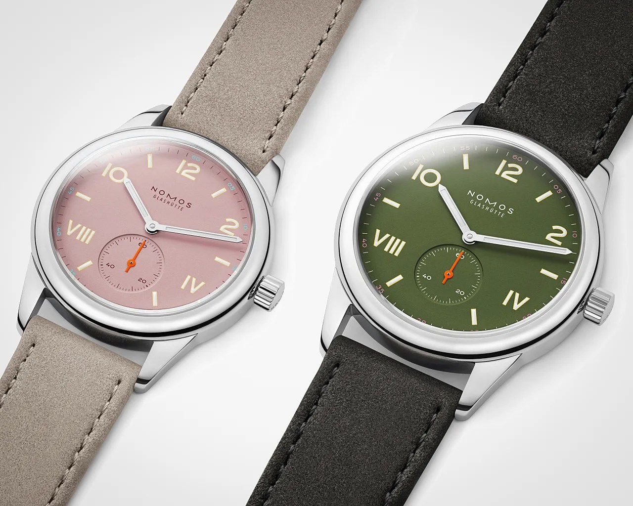 Two Nomos Glash&uuml;tte wristwatches with stainless steel cases, one with a pink dial and beige strap, the other with a green dial and black strap.