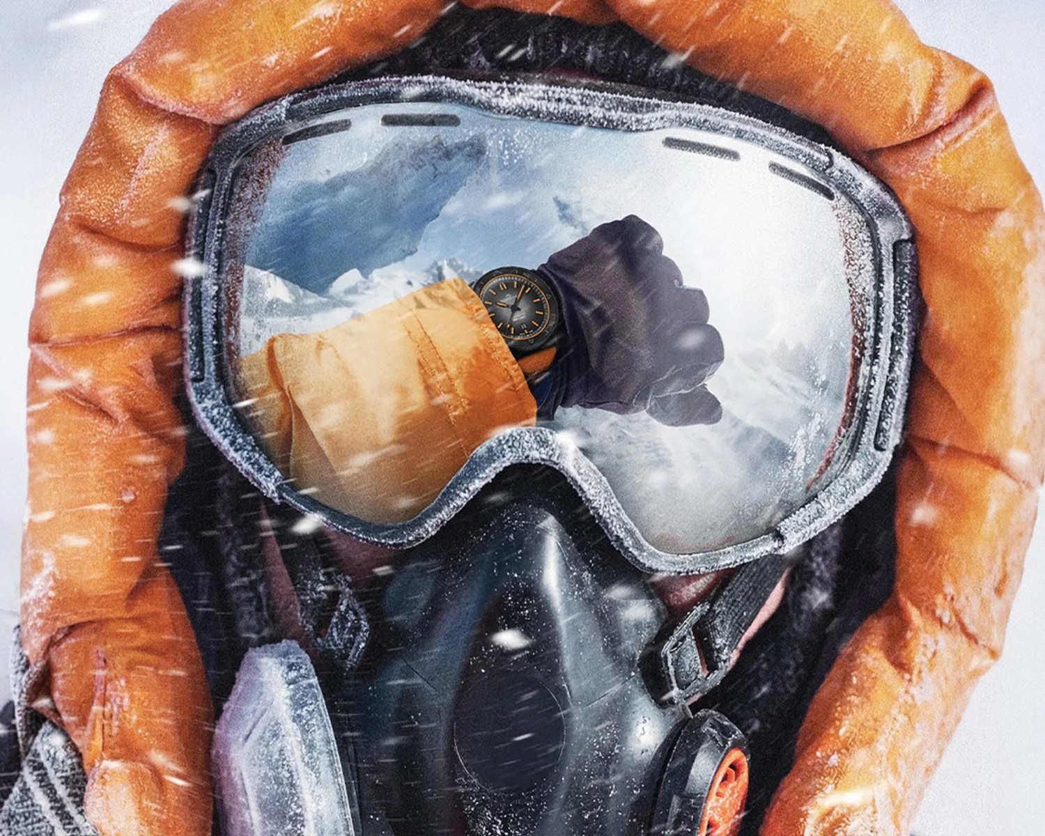 Close-up of a person wearing frosted ski goggles and an orange hooded jacket, with a black glove and watch reflected in the goggles.