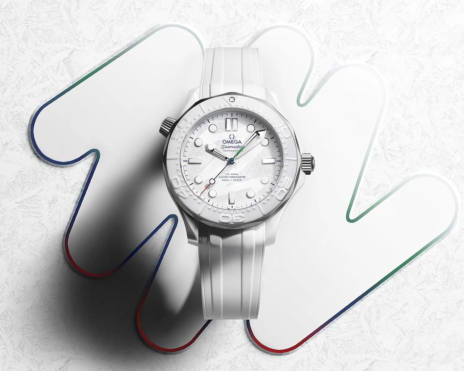 White Omega Seamaster wristwatch with a white rubber strap on a white textured surface with a multicolored outline.