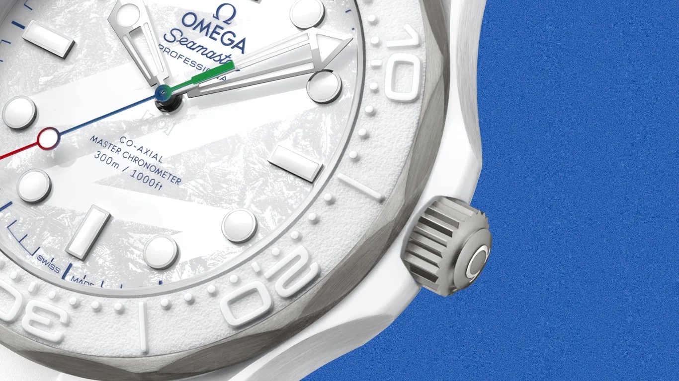 Close-up of a white Omega Seamaster Professional watch face with textured dial and rotating bezel against a blue background.