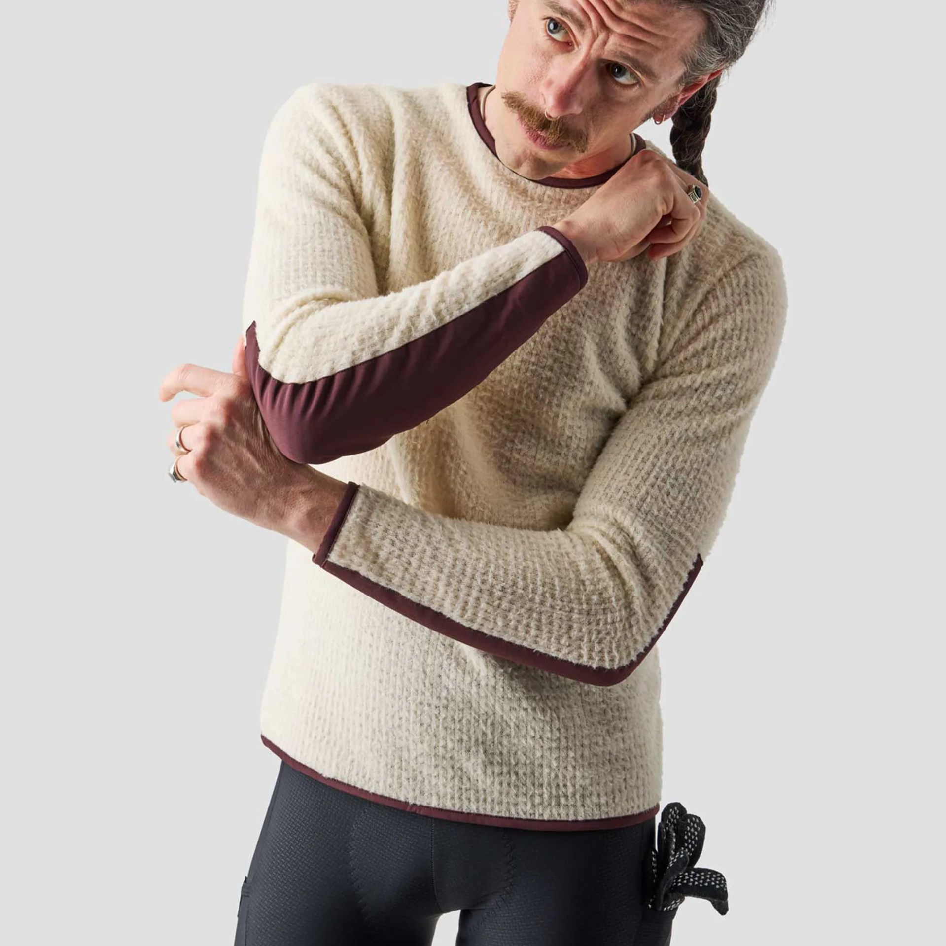 Cream textured long-sleeve sweater with maroon trim and underarm panels worn by a person.