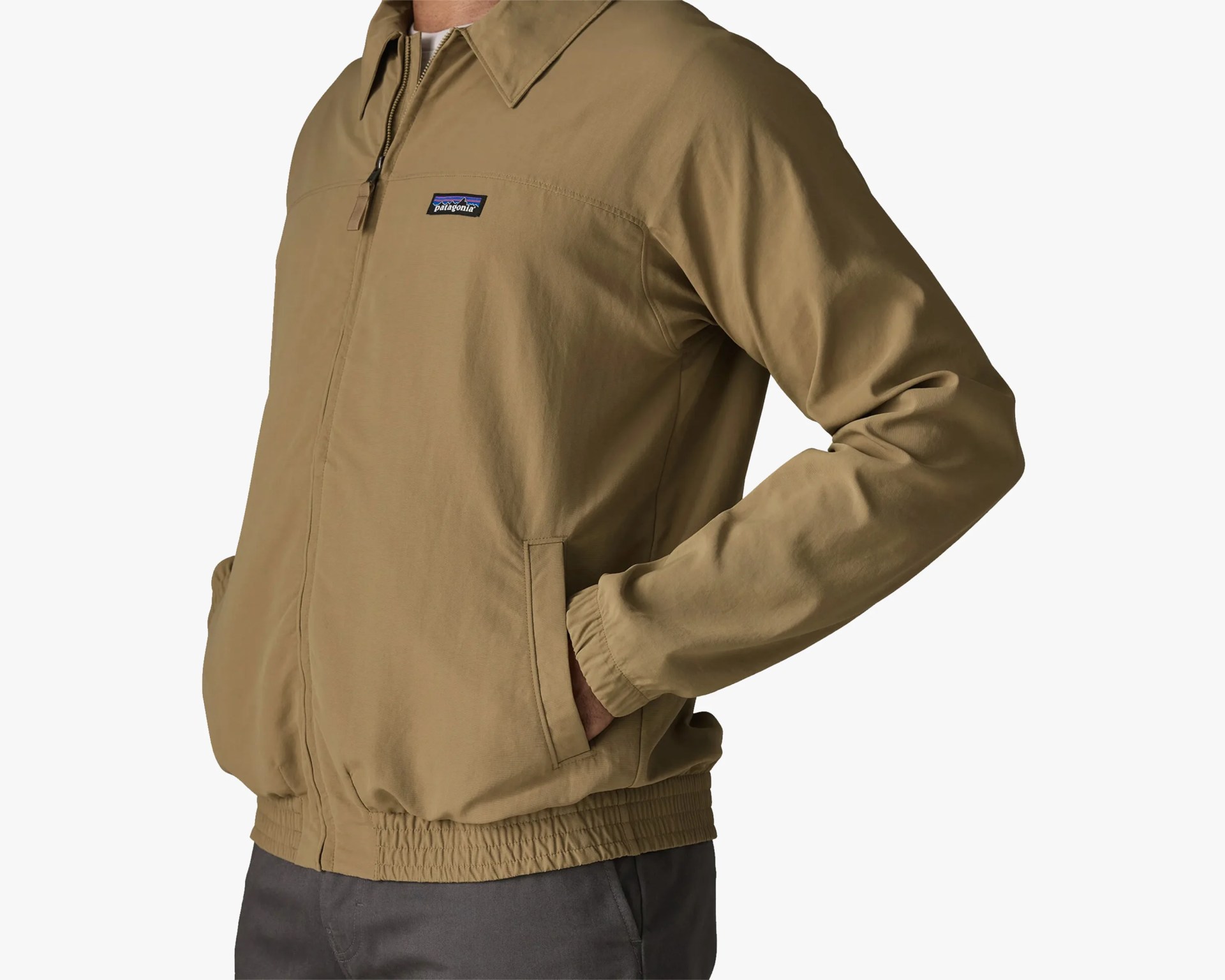 Light brown Patagonia zip-up jacket with elastic cuffs and waistband worn by a person.