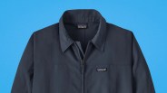 Navy blue Patagonia zip-up jacket with collar and logo patch on chest.